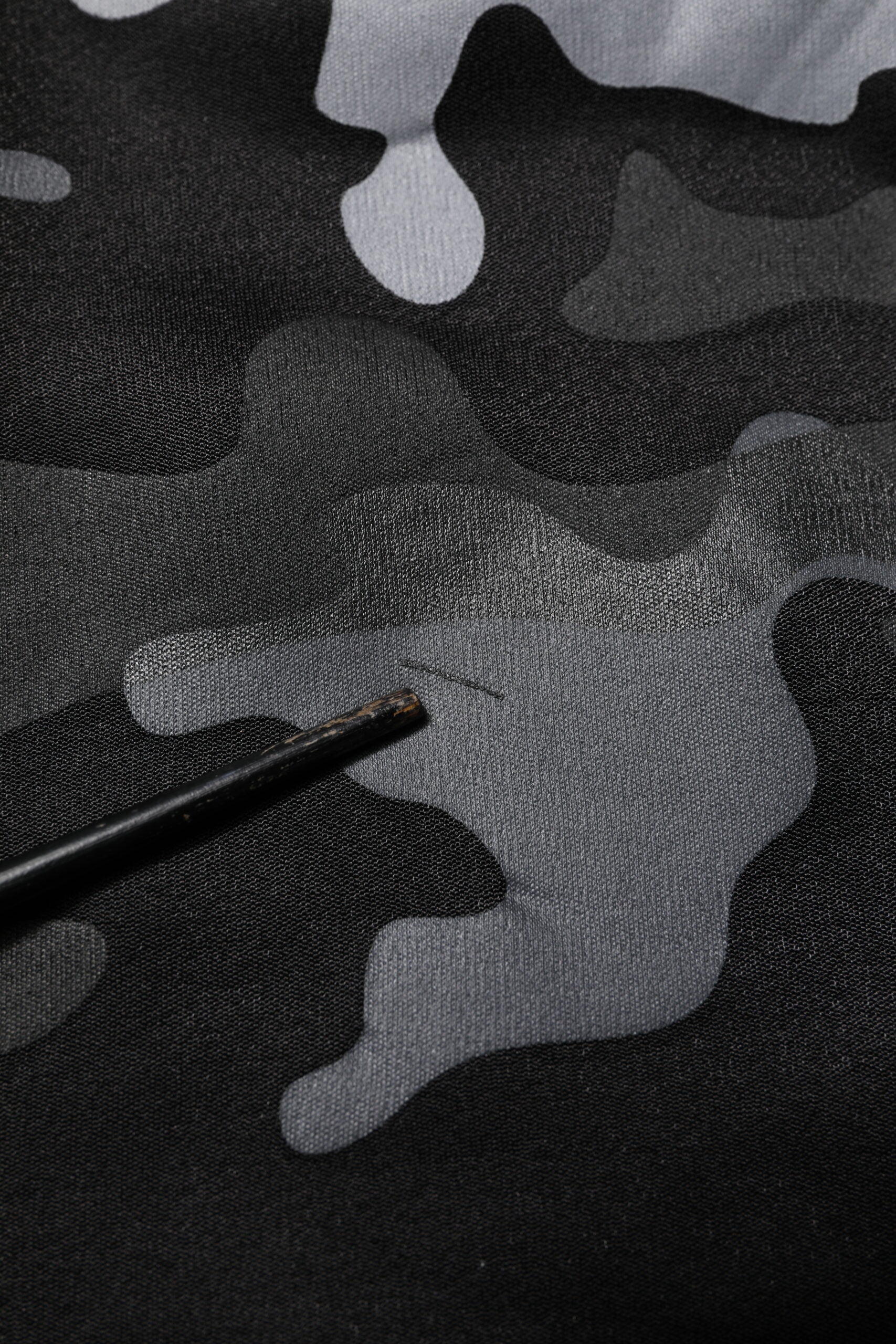 Camouflage fabric with a black pen marking on it