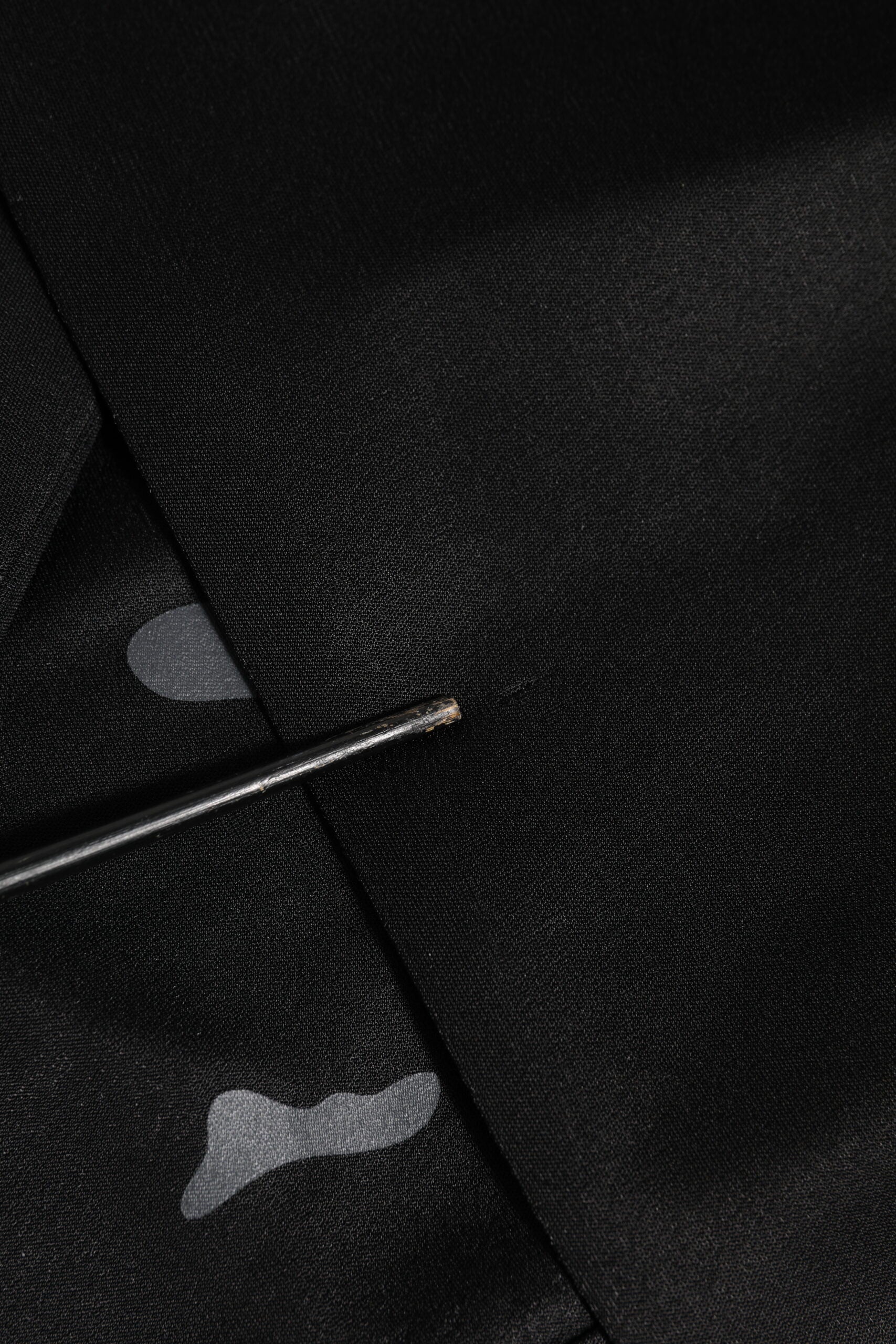 Black fabric with a small hole in it