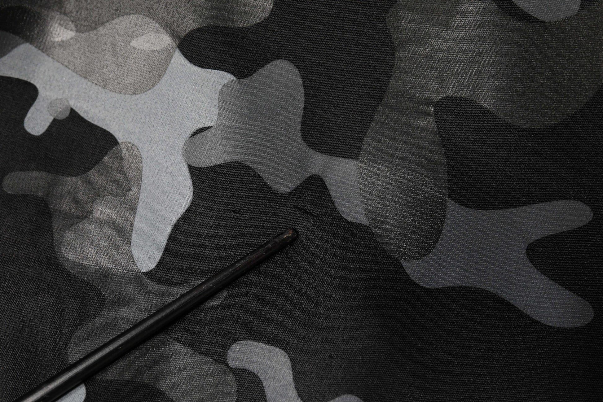 Camouflage fabric with a black object on top