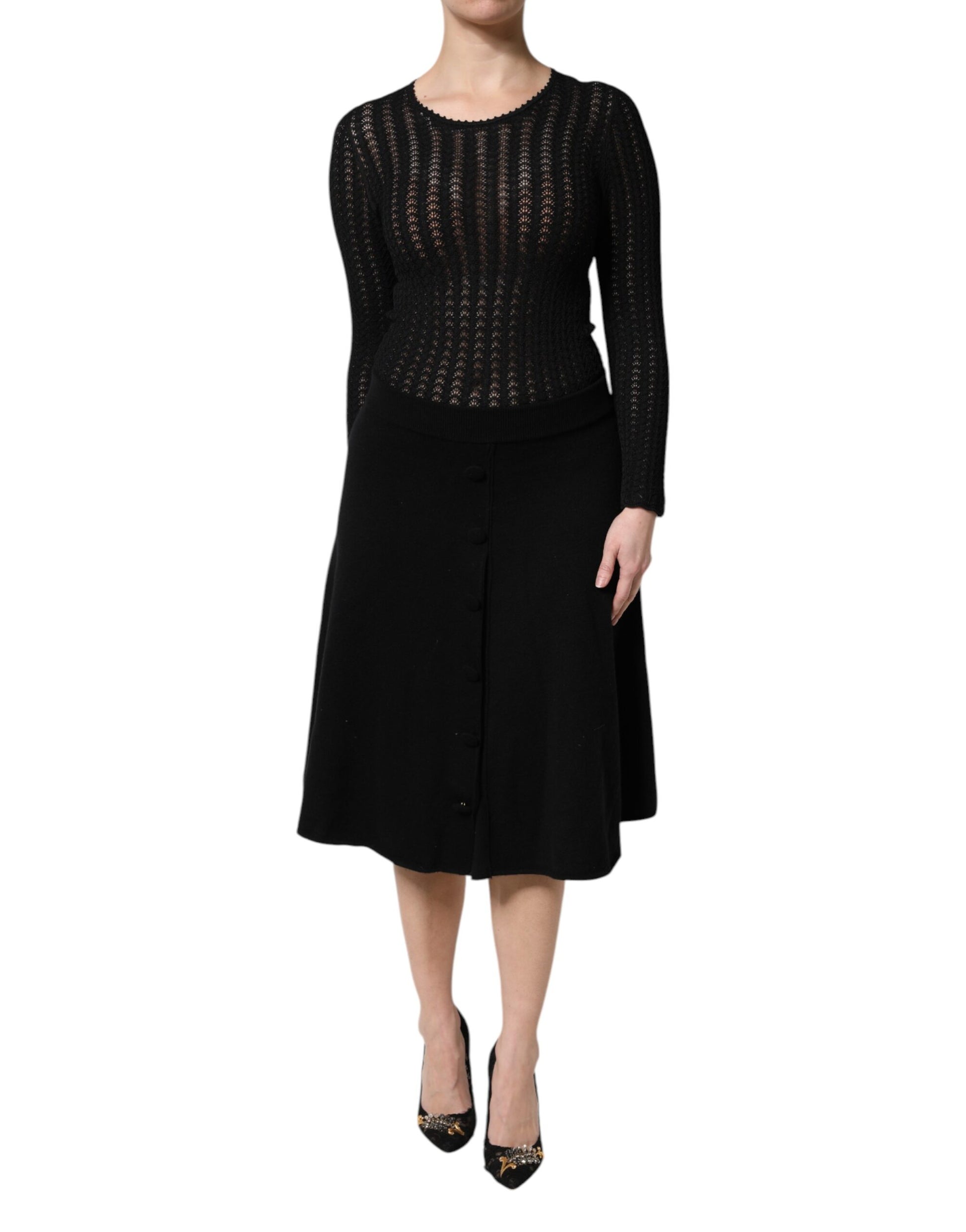 A black cashmere midi dress with long sleeves and an A-line skirt. It features a textured knit pattern and is