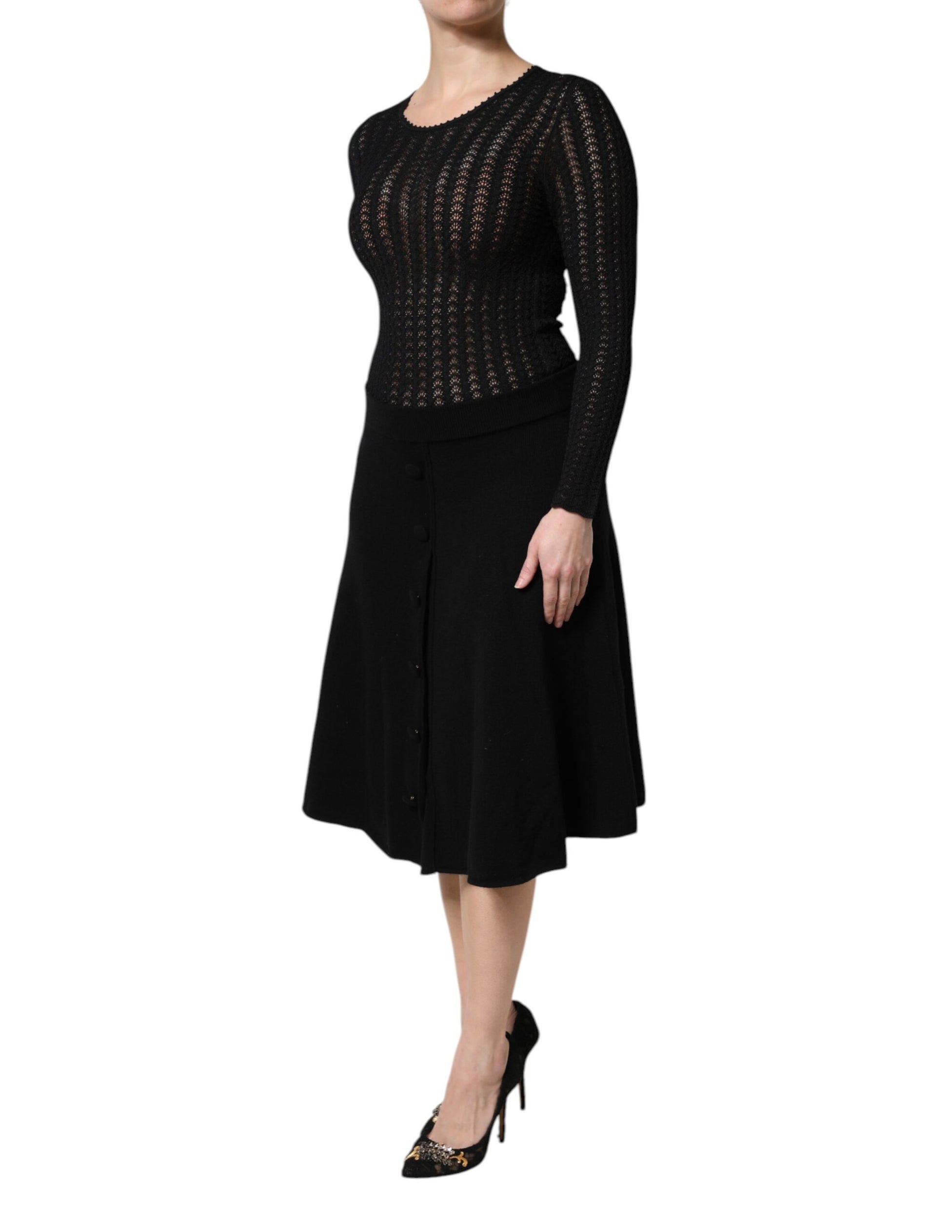 A black cashmere midi dress with long sleeves and an A-line skirt. It features a lace bodice and is designed