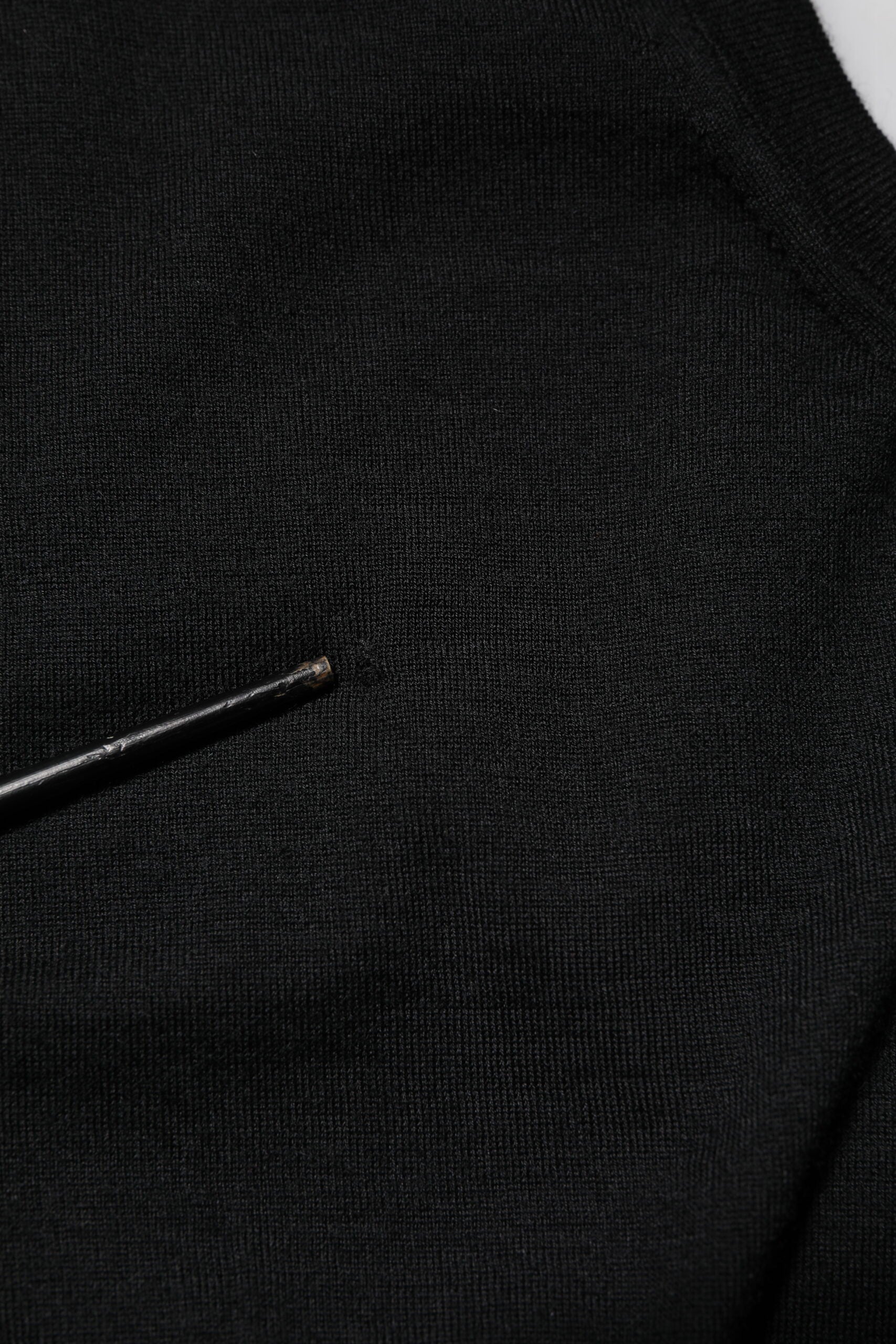 Black fabric with a small black pin in it