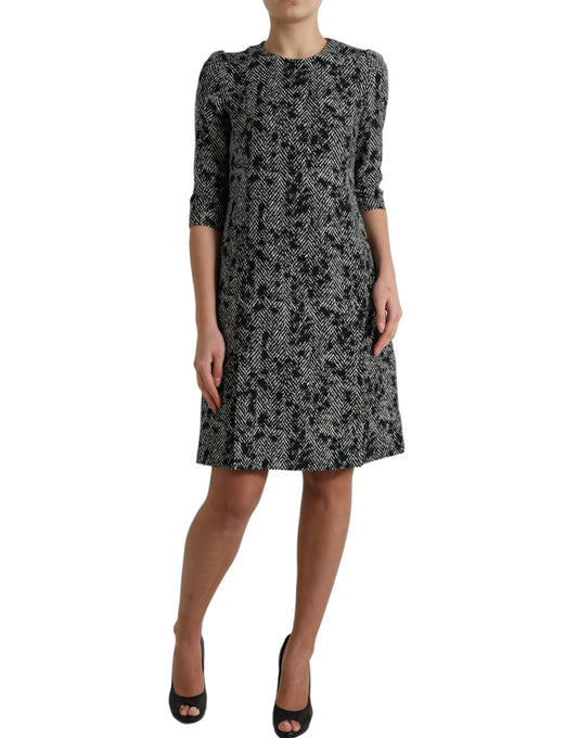 A black chevron patterned dress with short sleeves and a knee-length skirt