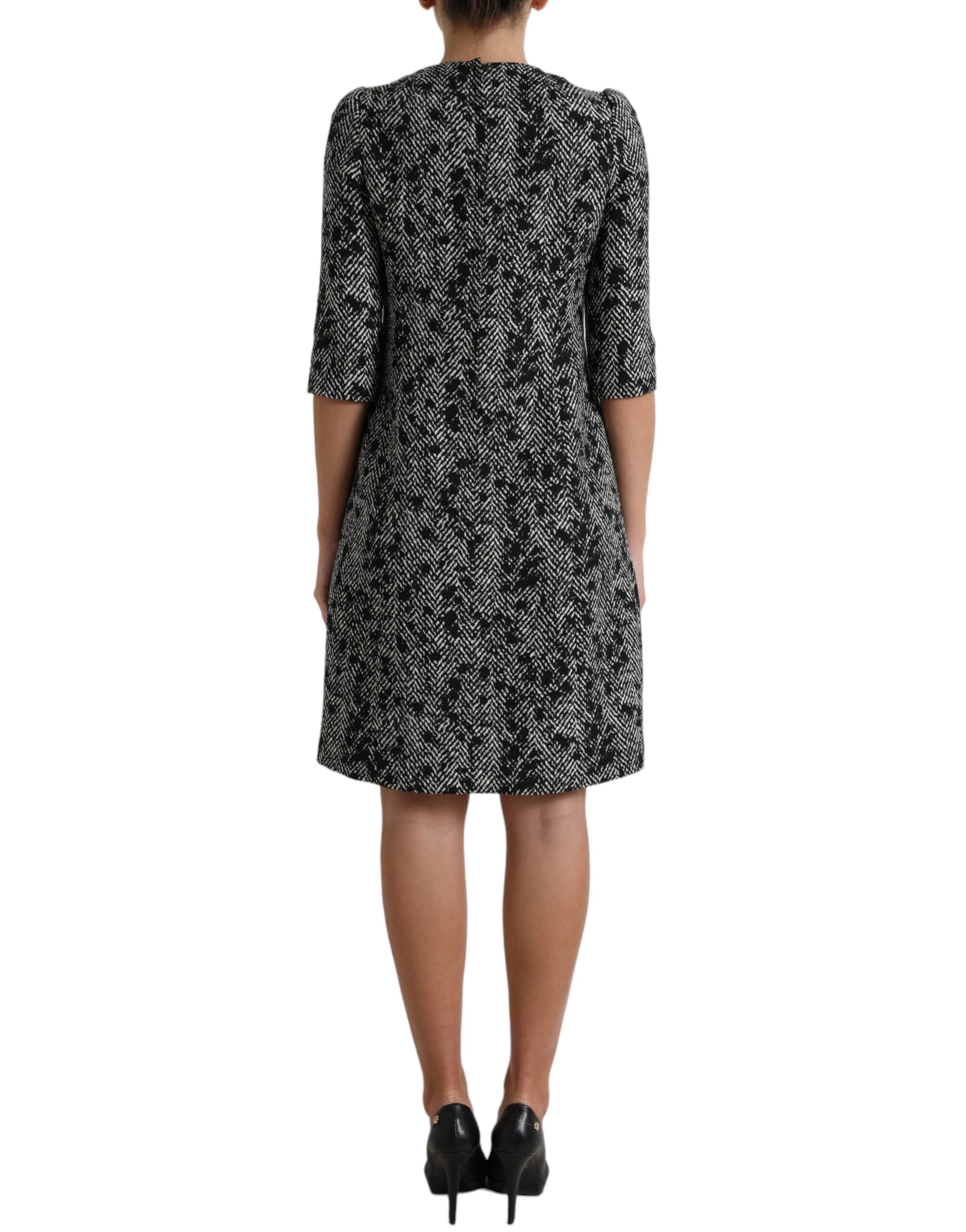 A black chevron patterned dress with short sleeves and a knee-length skirt