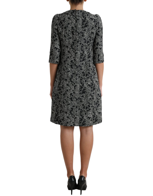 A black chevron patterned dress with short sleeves and a knee-length skirt