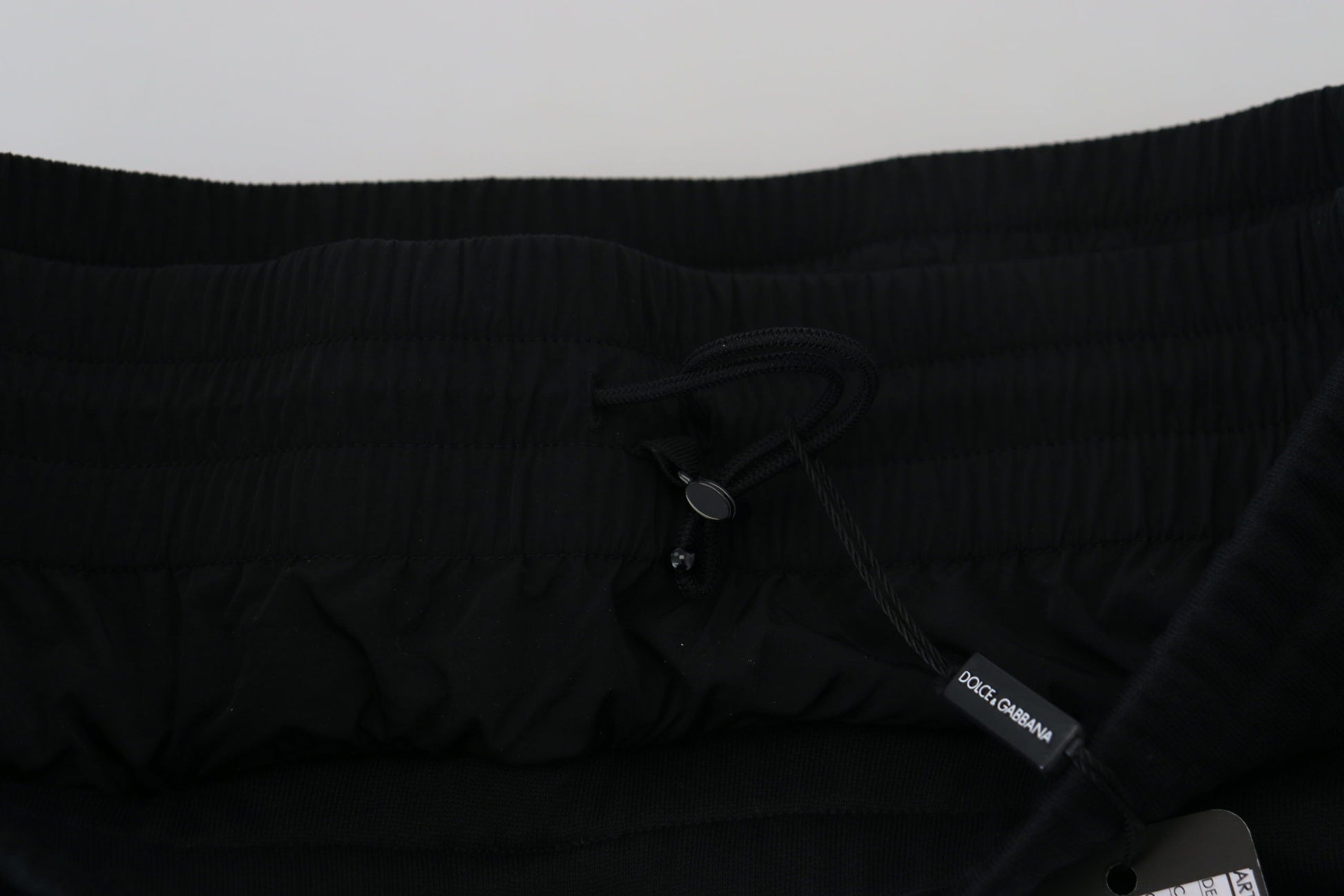 Black garment with a tag attached to the neckline