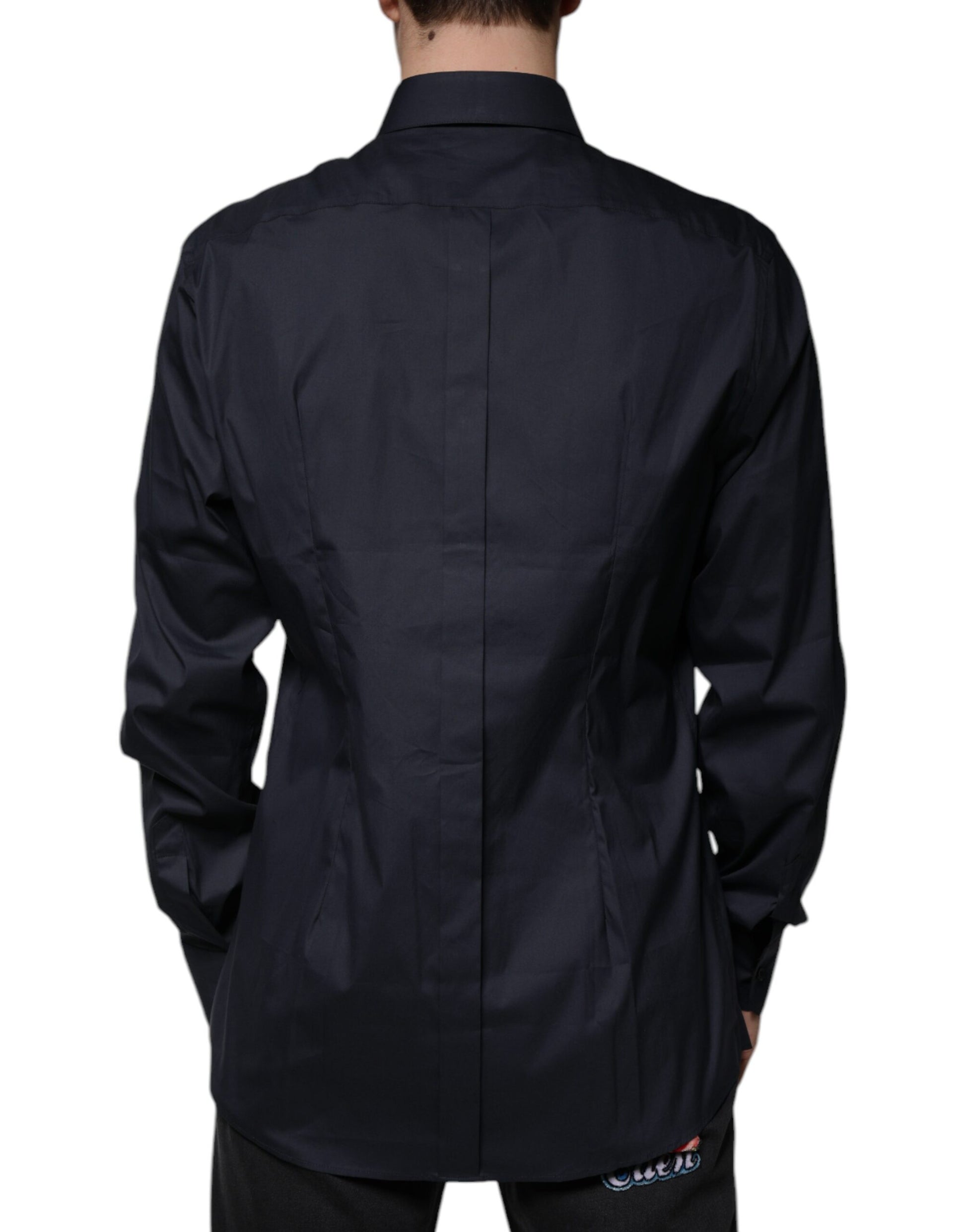 A black dress shirt with a gold emblem on the left chest area