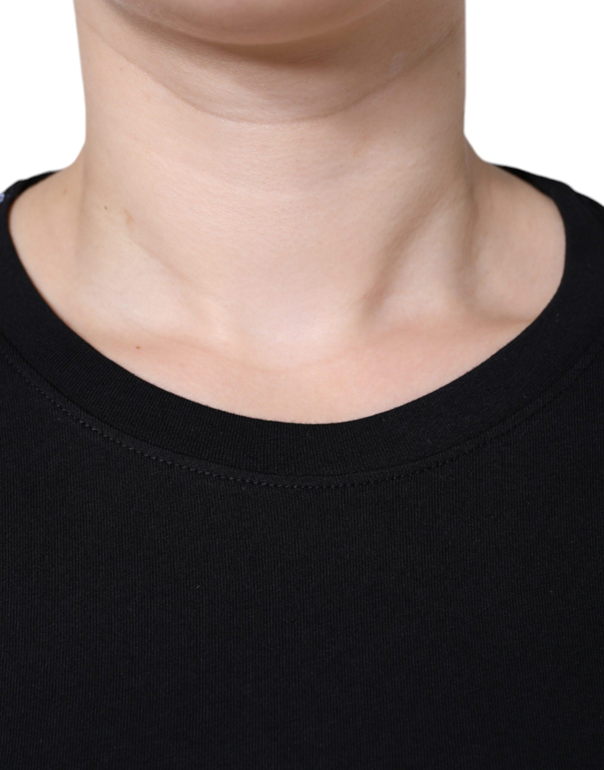 A person's neck area wearing a black top