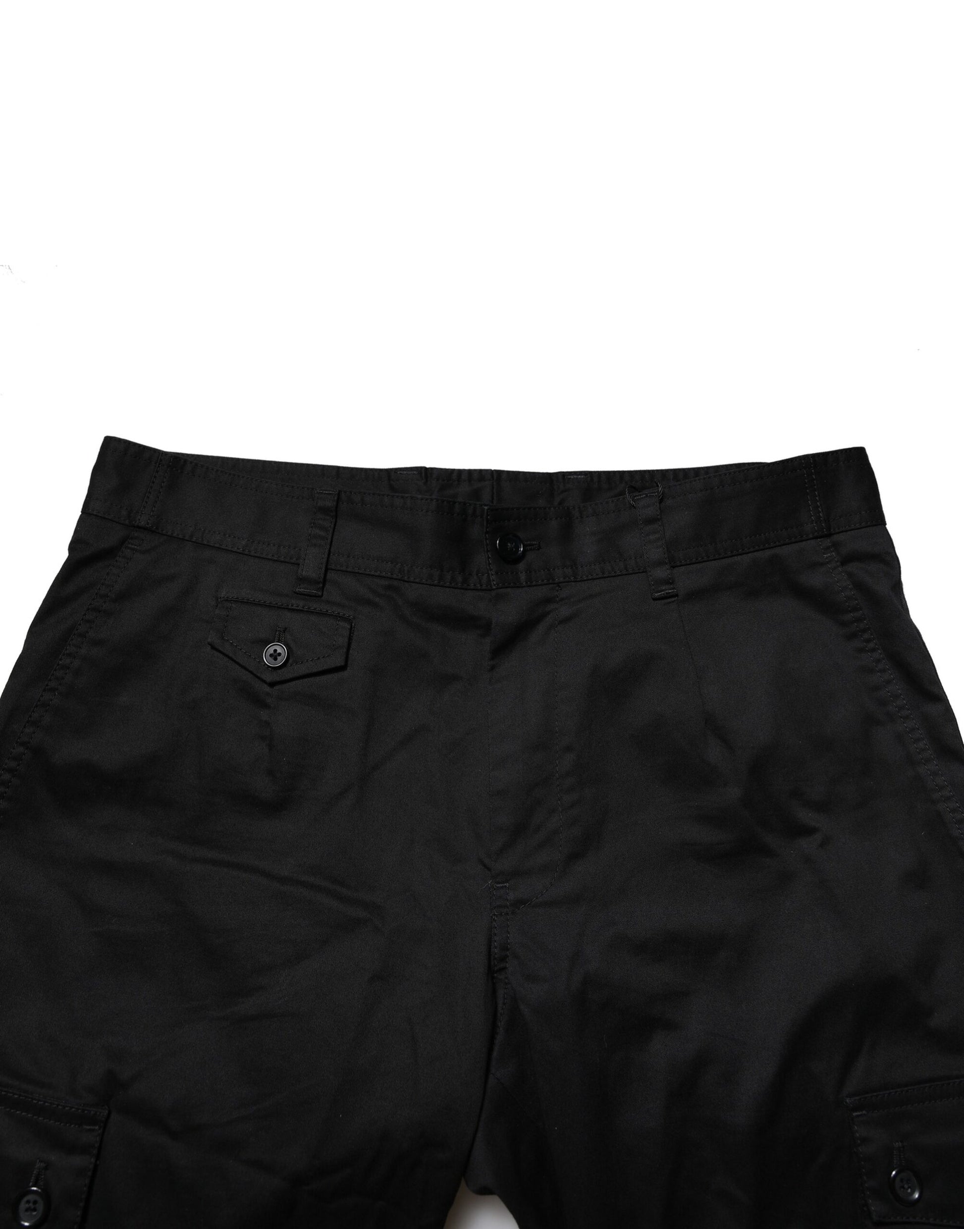 A pair of black cotton dress pants with a slim fit and formal design, featuring two front pockets