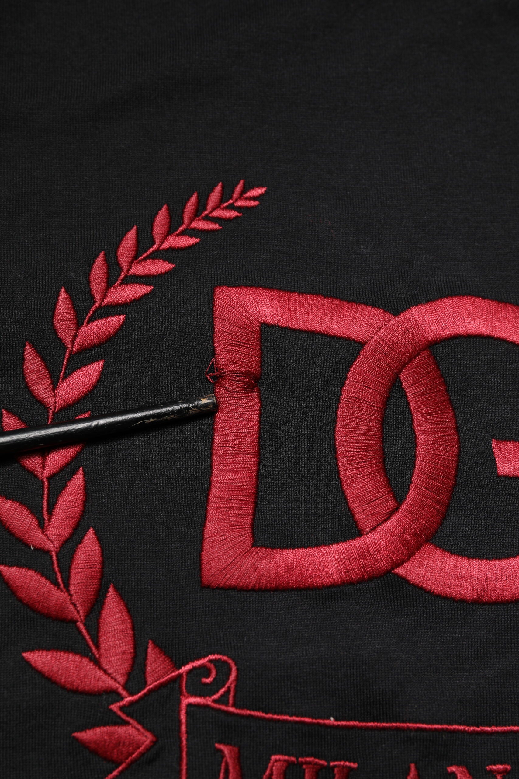 Red embroidered letters on black fabric