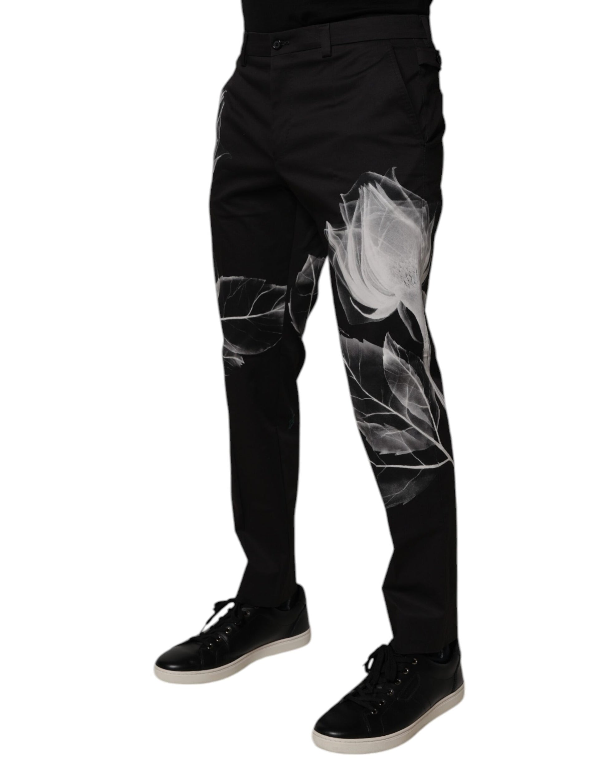 A pair of black cotton skinny dress pants with a floral pattern on the legs