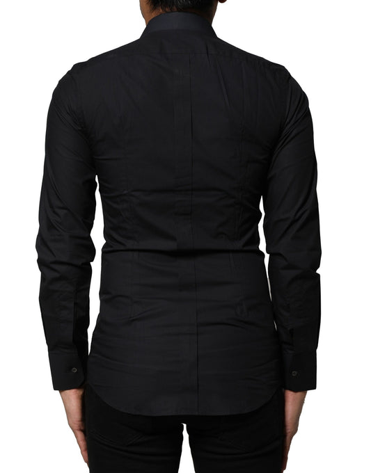 A black cotton dress shirt with long sleeves and gold accents