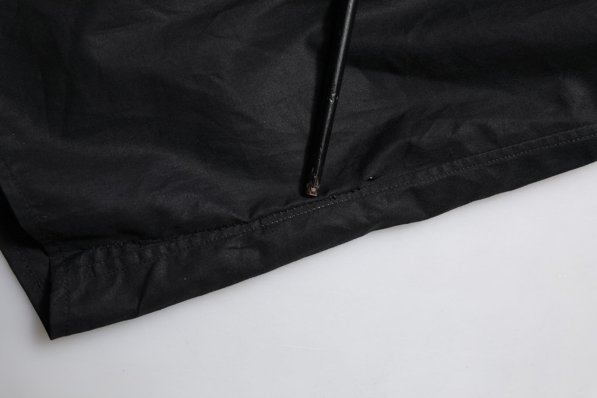 A black cotton dress shirt with long sleeves and a gold zipper