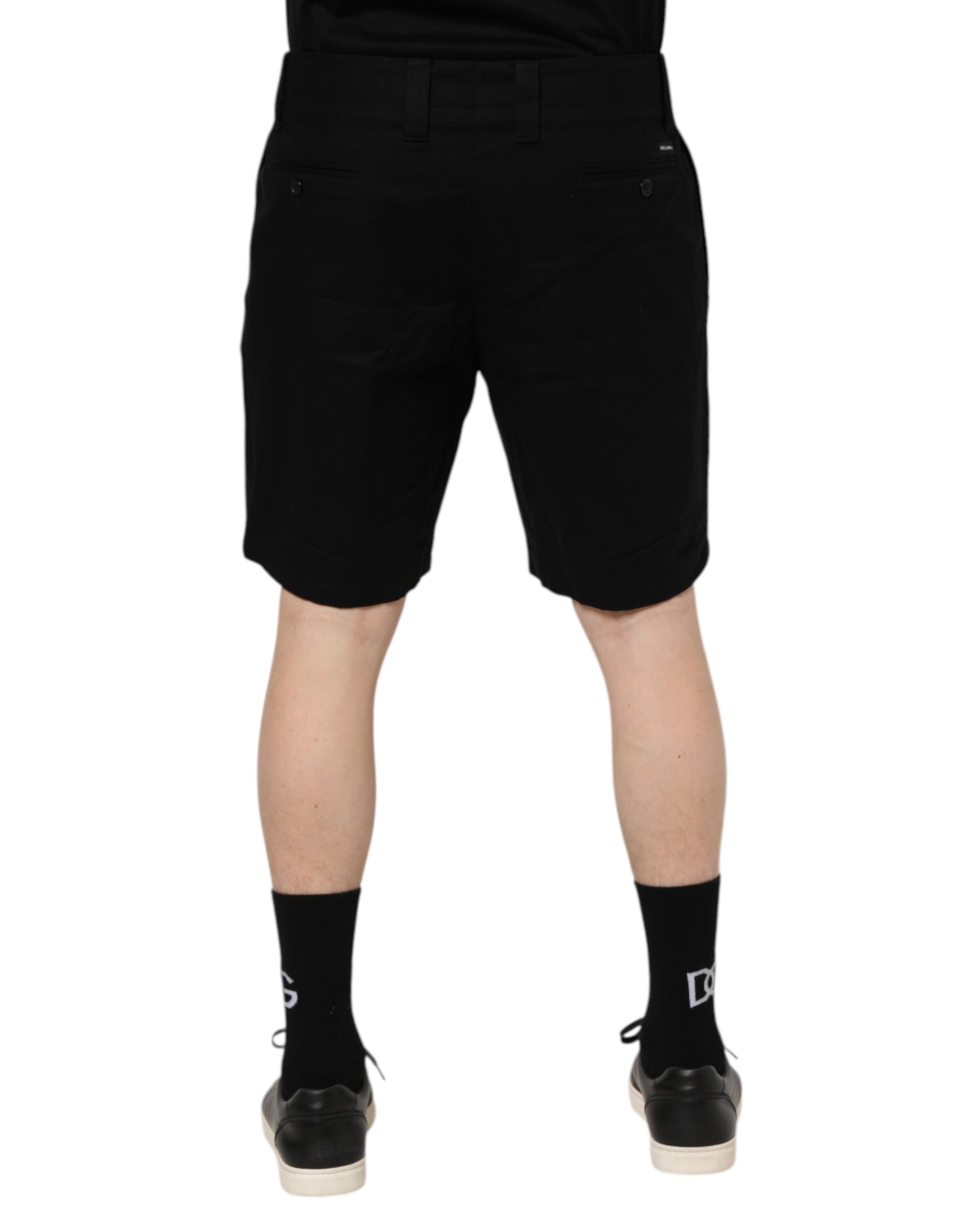 Black shorts on a person standing against white background