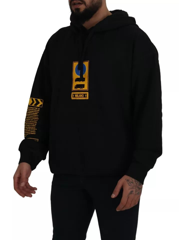 Man wearing black hoodie with yellow logo on sleeve