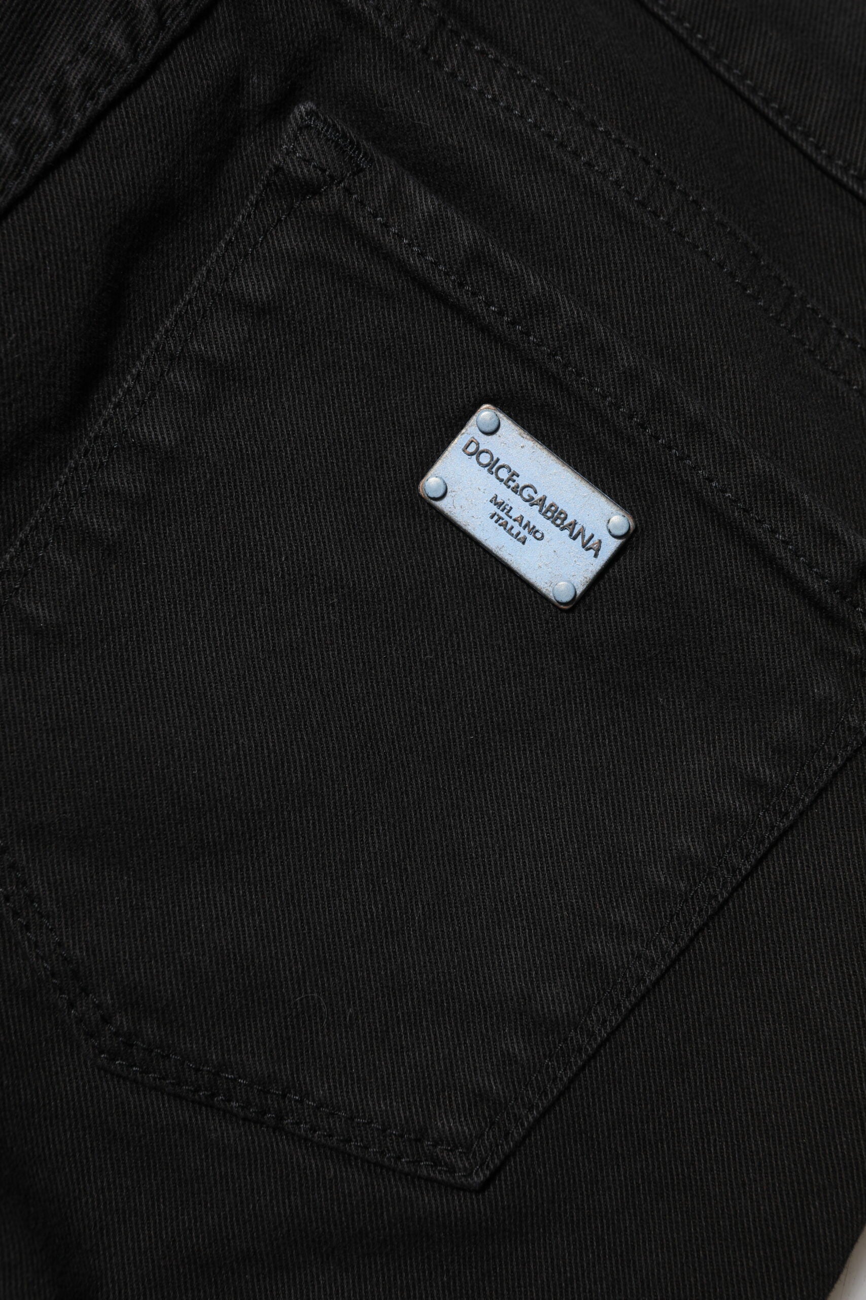 Black denim jeans with a white tag on the left side