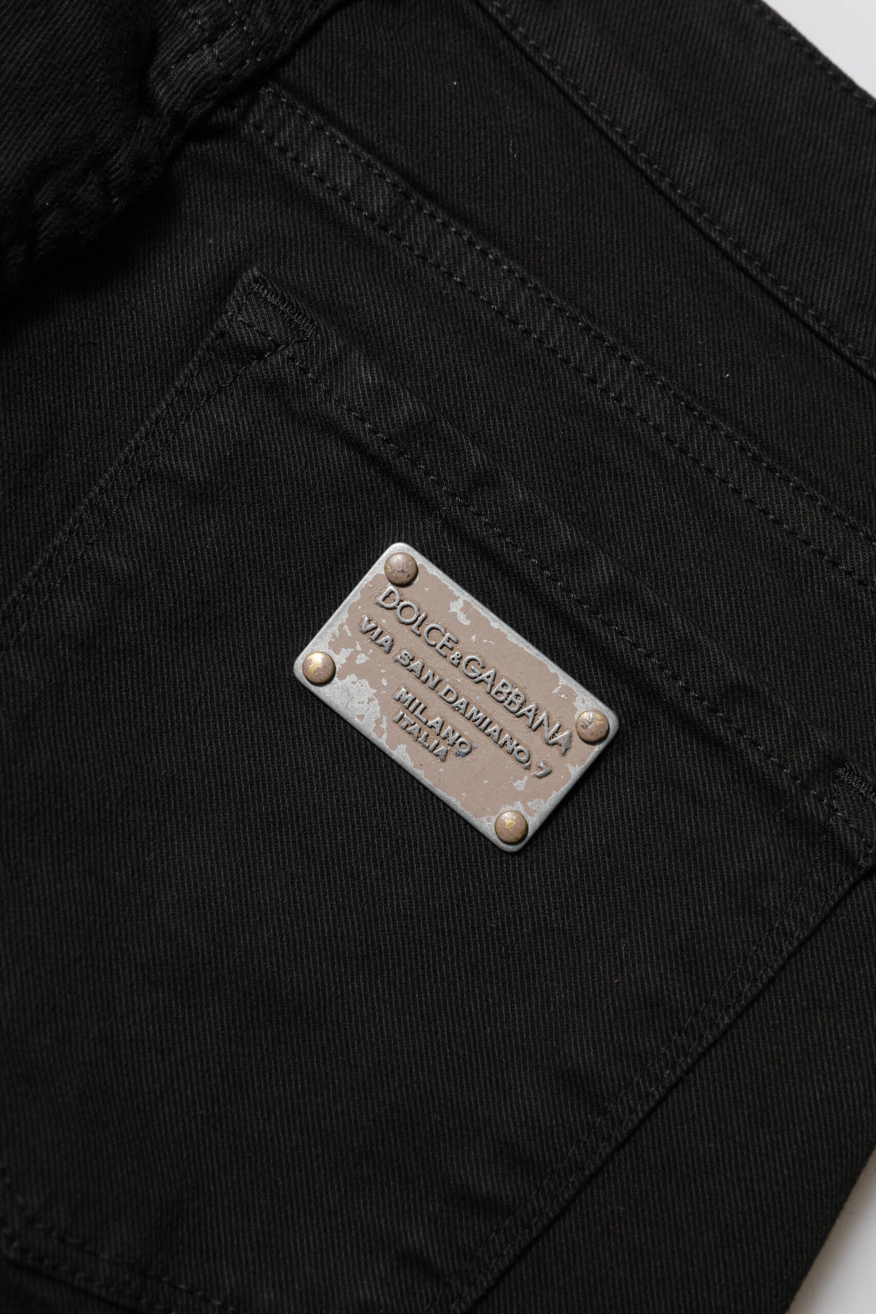 Silver metal name tag on black fabric