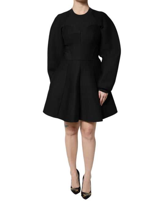 A black cotton dress with long sleeves and an A-line skirt. It is designed by Dolce & Gabbana and features a