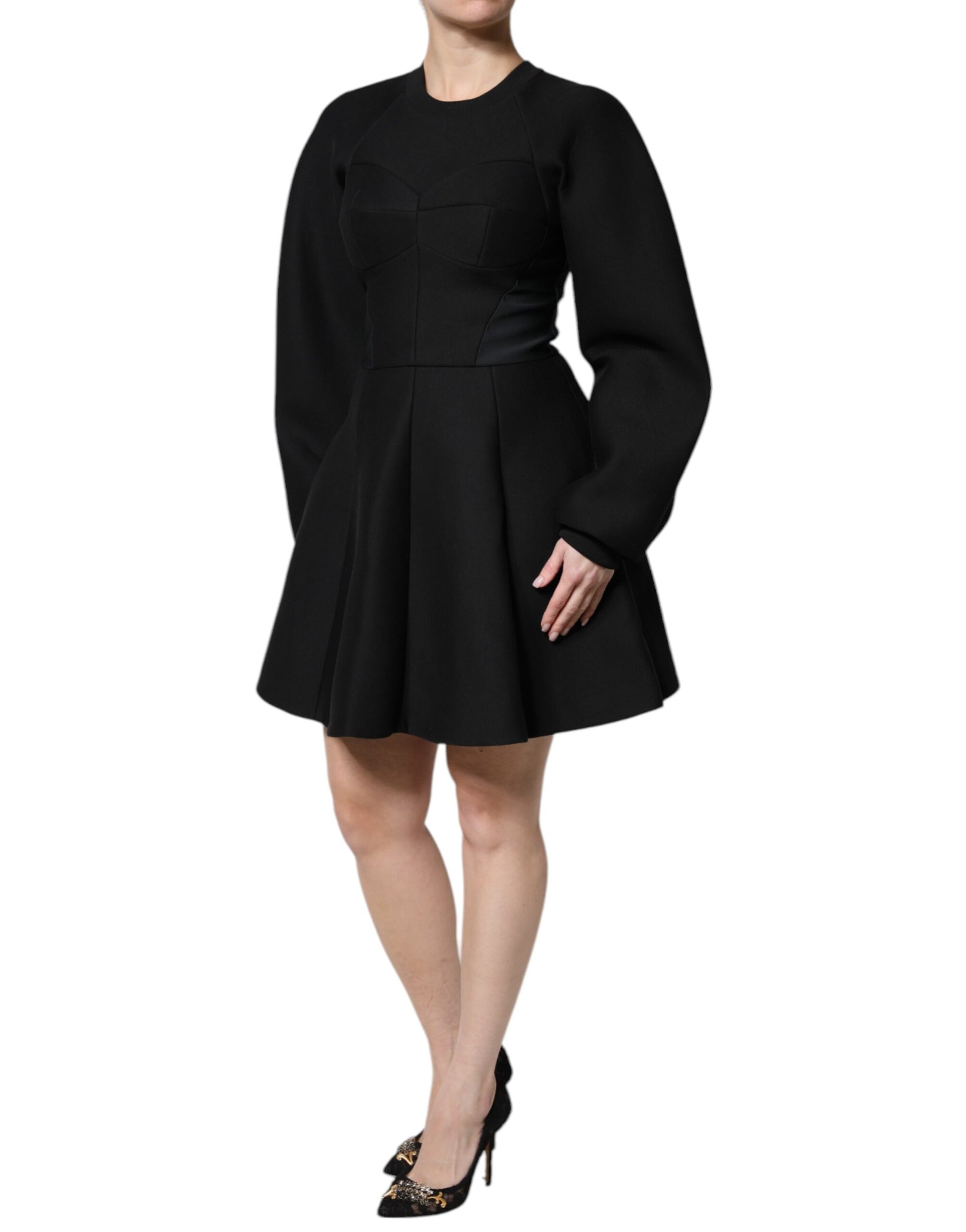 A black cotton dress with long sleeves and an A-line skirt. It is designed by Dolce & Gabbana, as indicated b