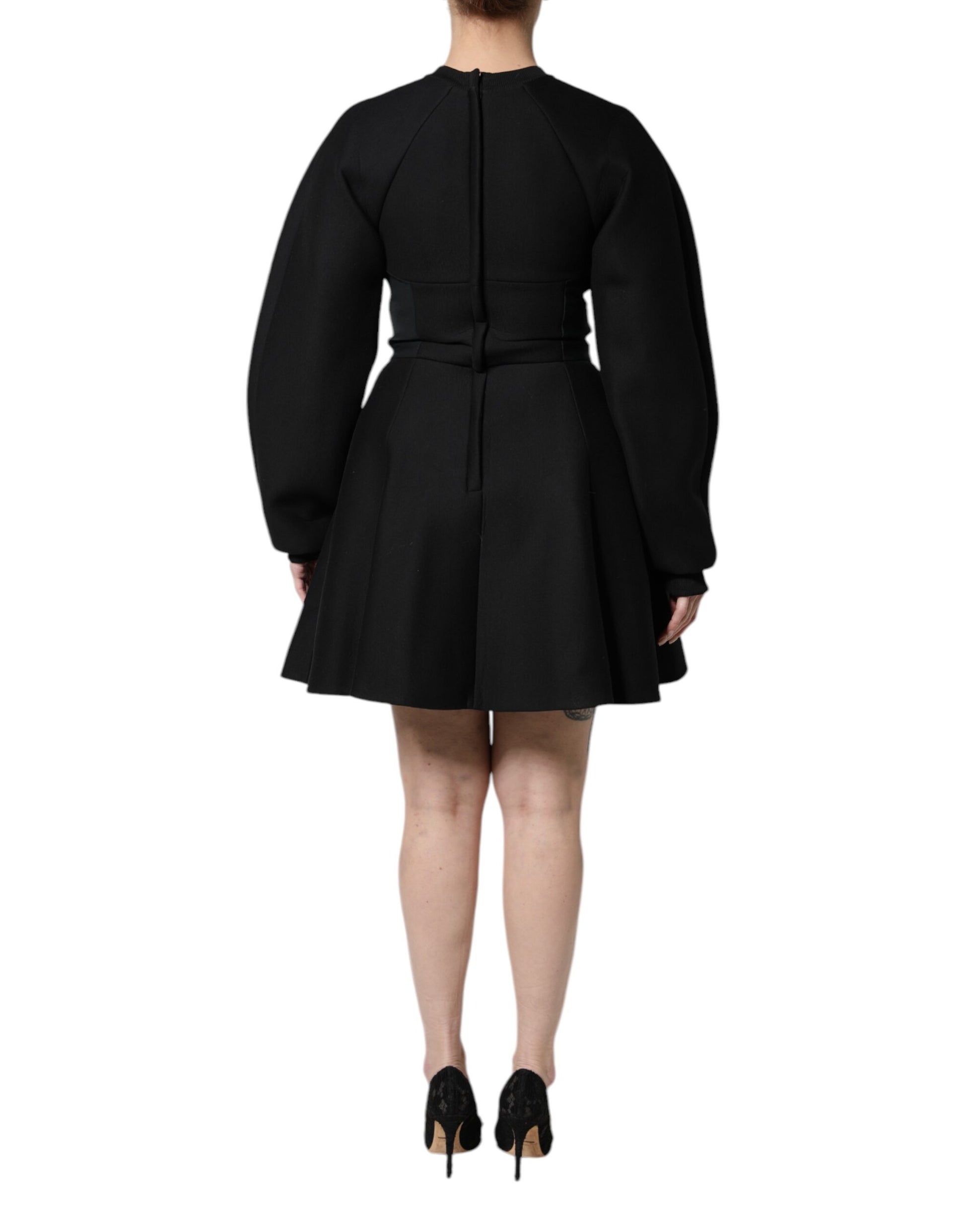 A black cotton dress with long sleeves and an A-line skirt. It is designed by Dolce & Gabbana, and it appears