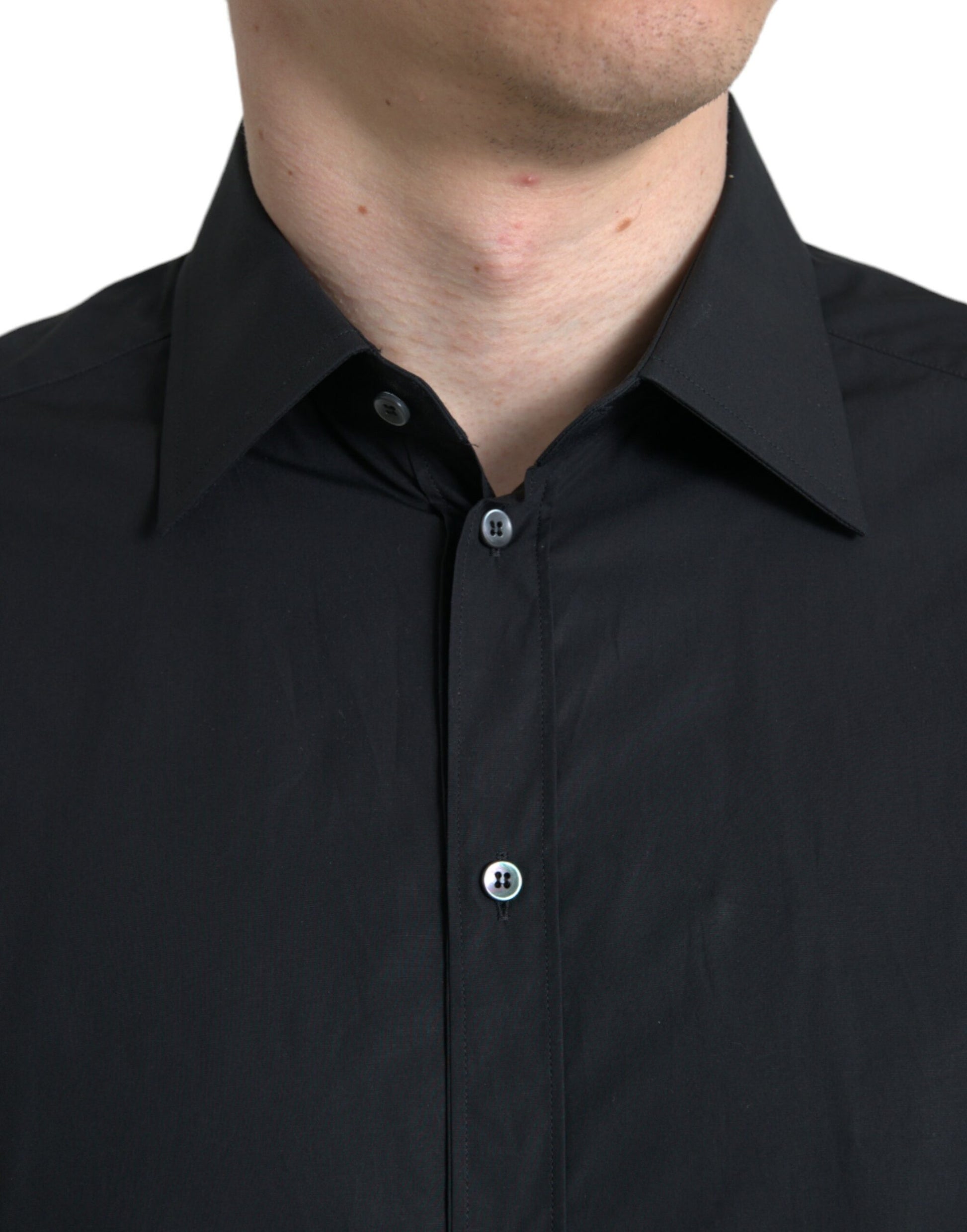 A black cotton men's formal dress shirt with a gold button and collar