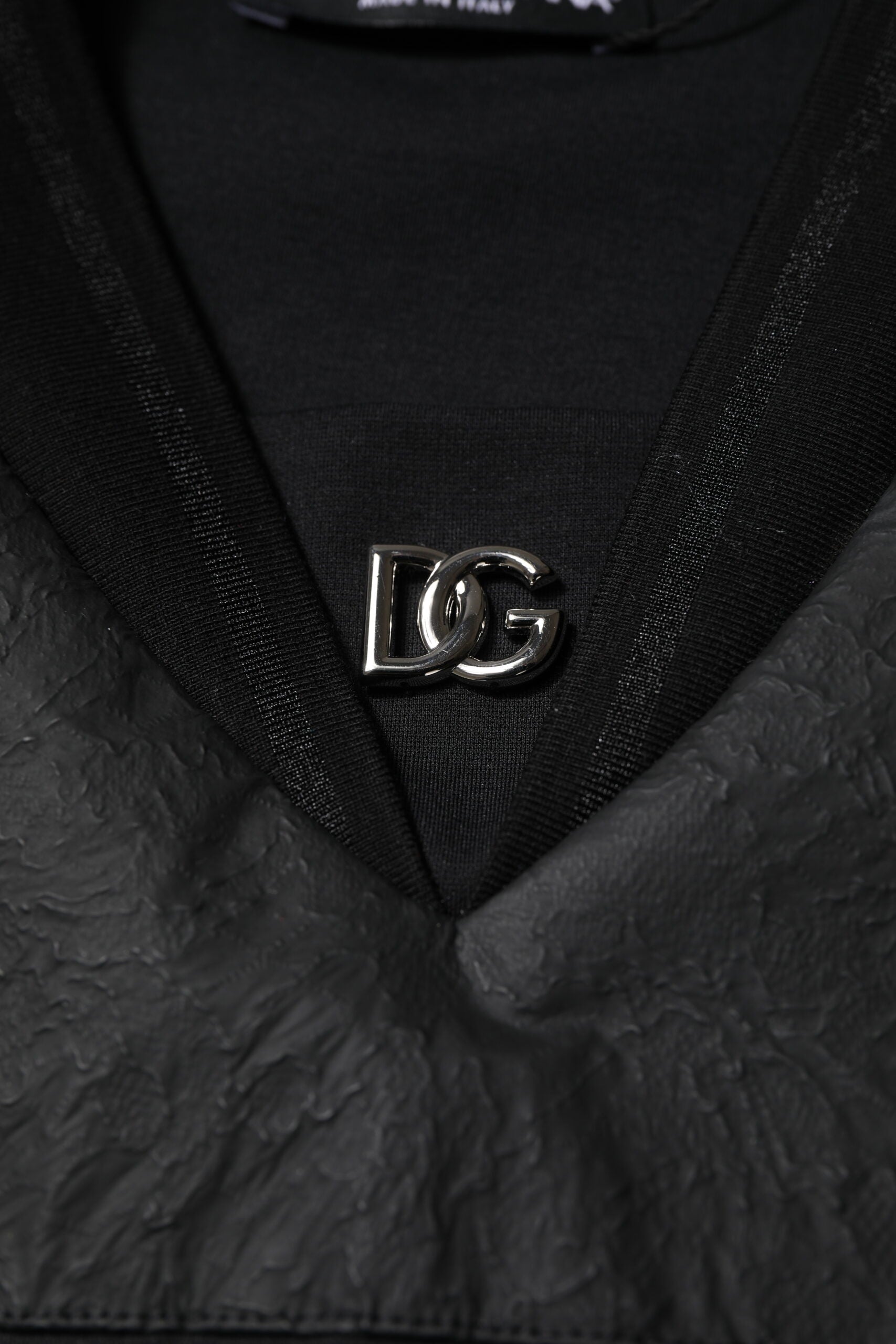 Black leather jacket with gold logo on front