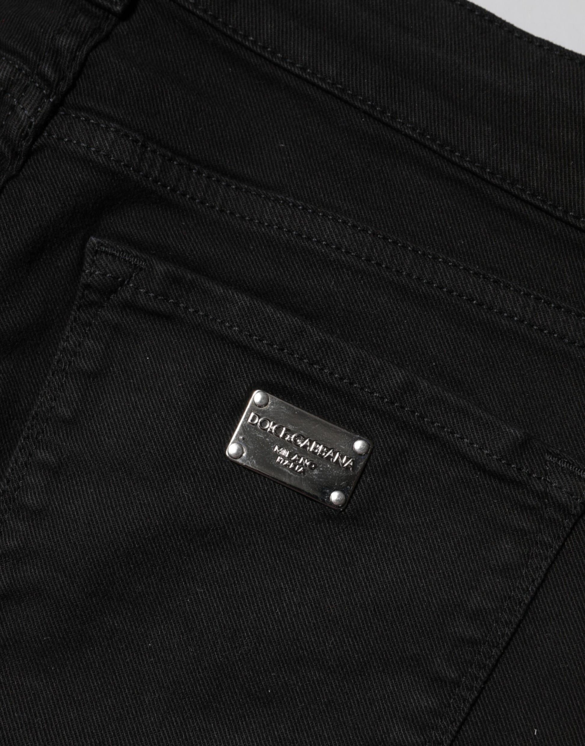 Black jeans with a silver label on the front pocket