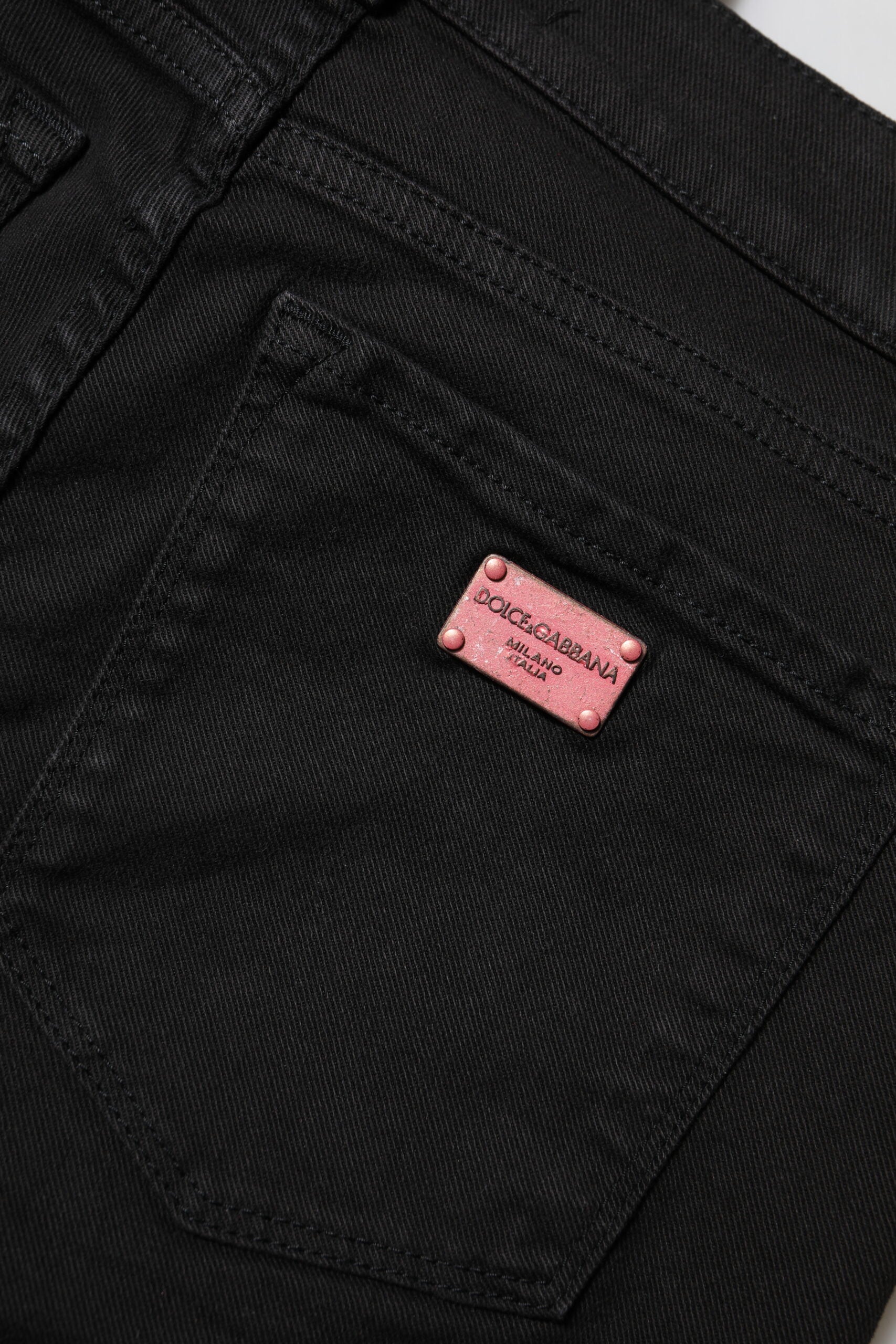 Black jeans with pink label on front pocket