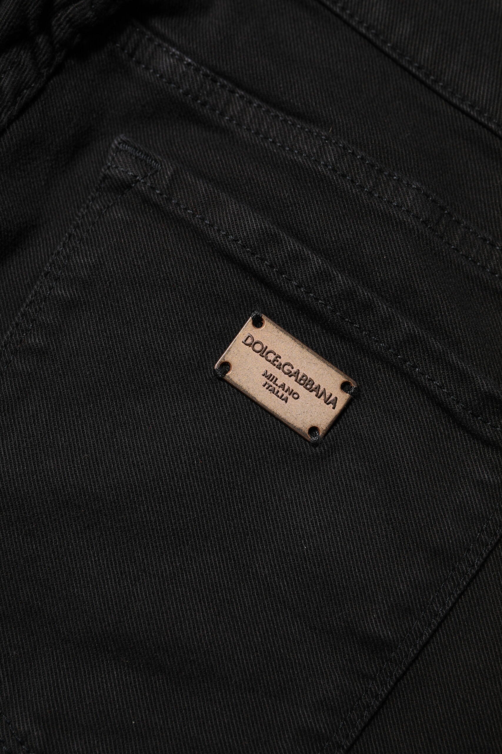 Black denim jeans with a small rectangular tag on the left side