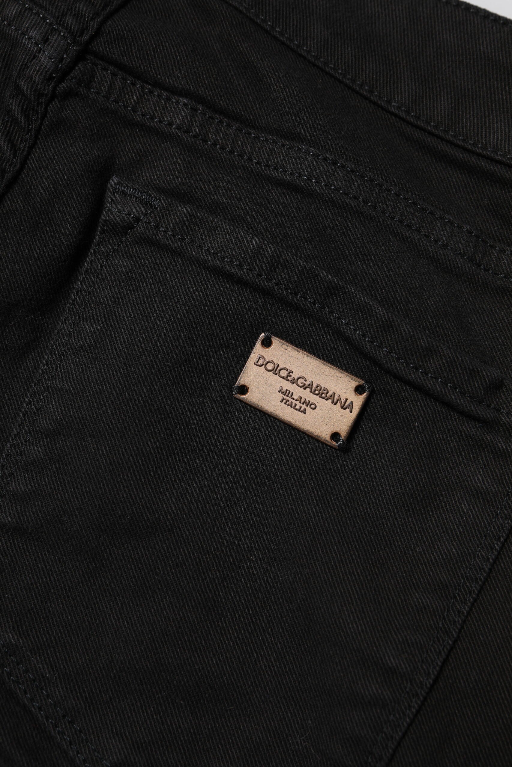 Black denim jeans with a small rectangular label on the back pocket