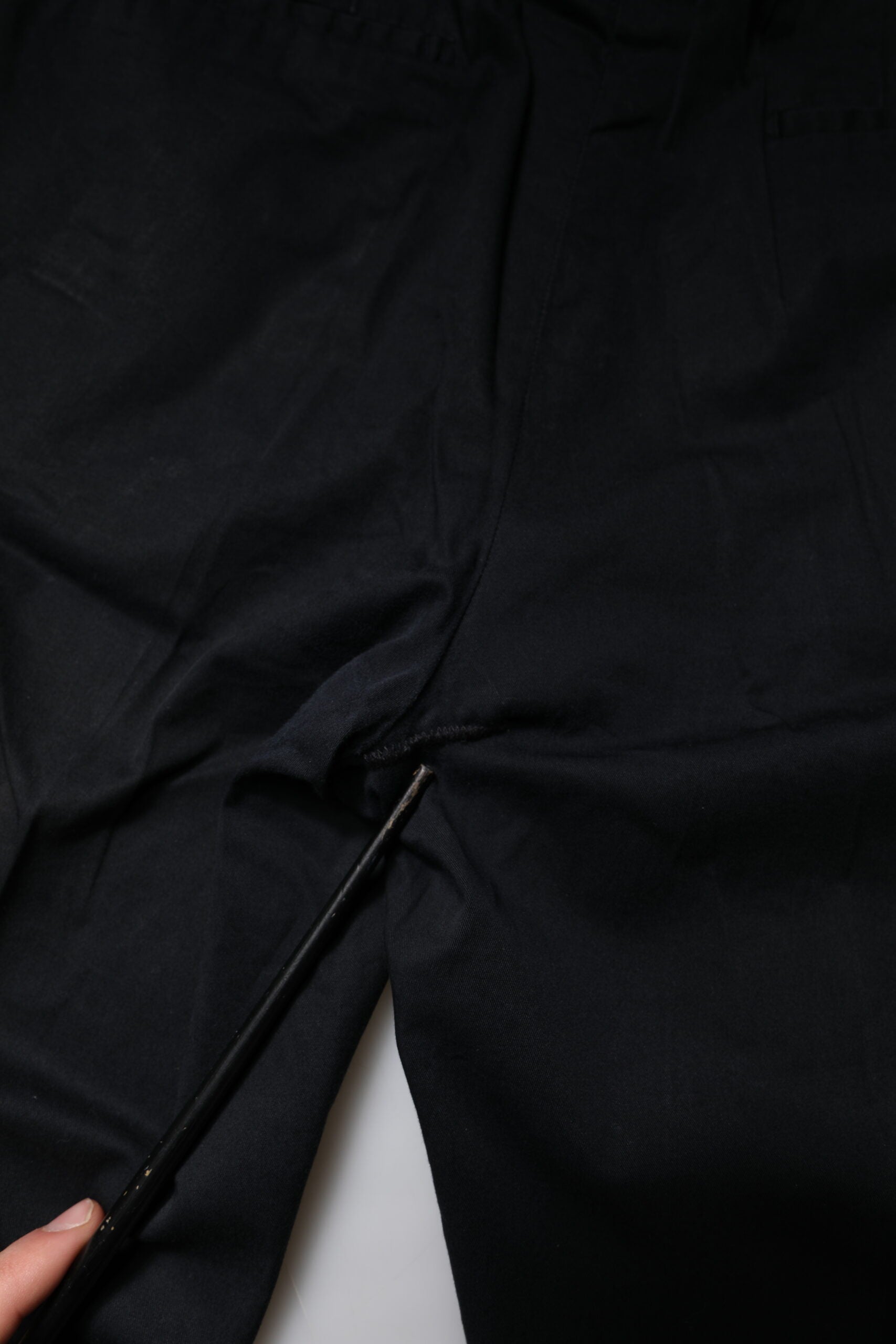 A pair of black cotton stretch skinny dress formal pants with a visible zipper fly