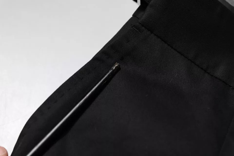 A pair of black tapered formal dress pants from the brand Dolce & Gabbana. They are made of cotton and featur