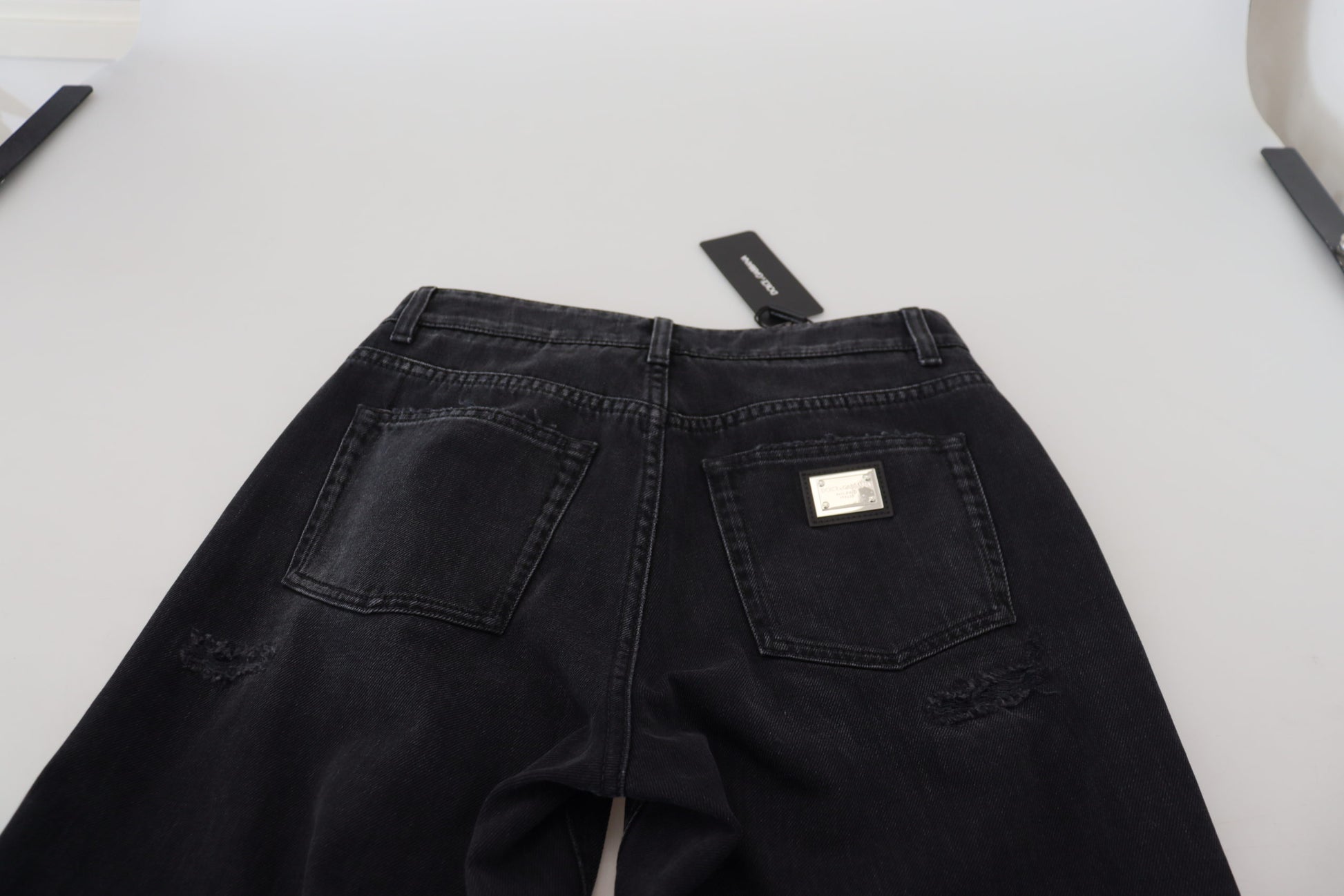 Black denim jeans on a white surface