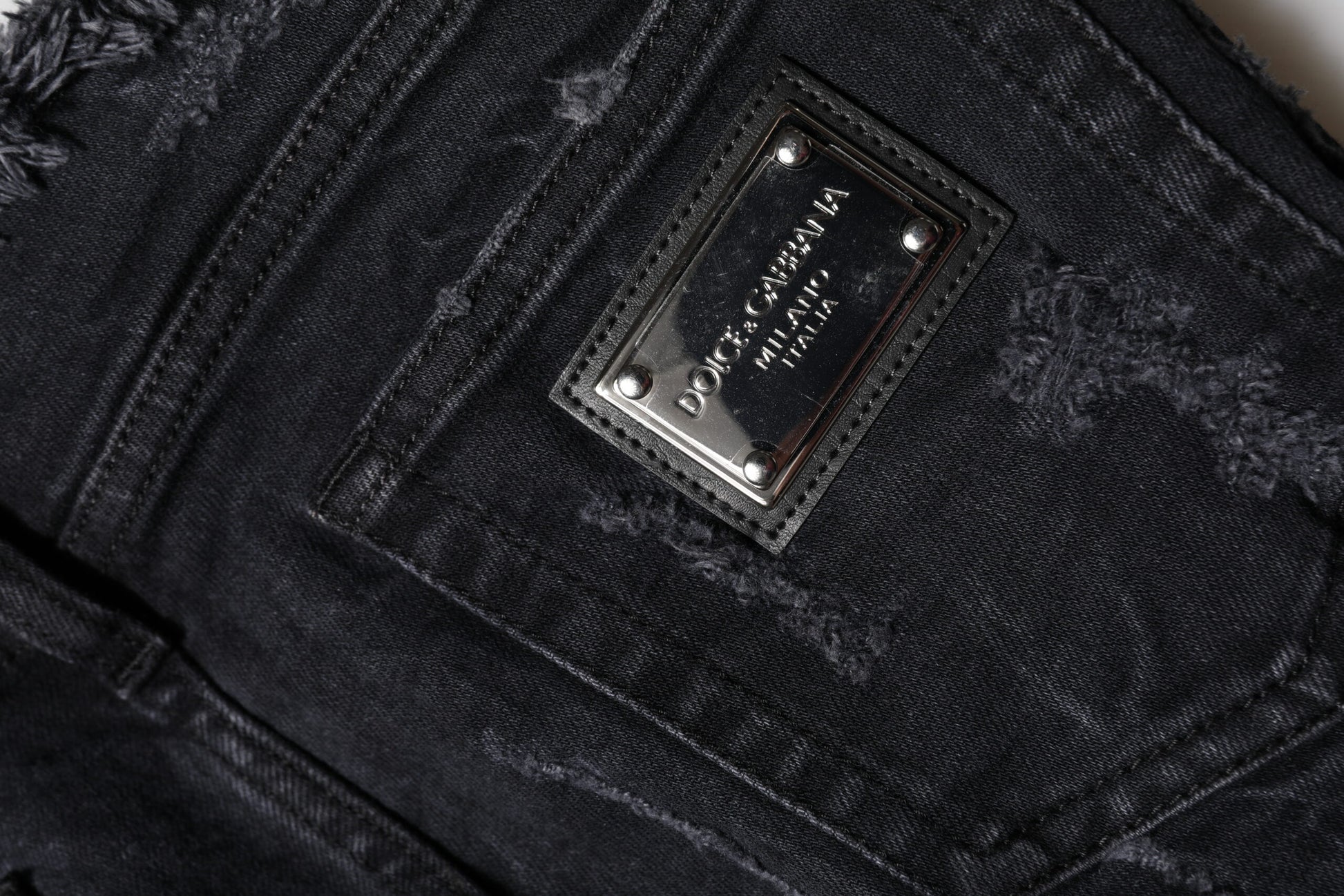 A close-up view of a pair of jeans with a visible brand label on the waistband