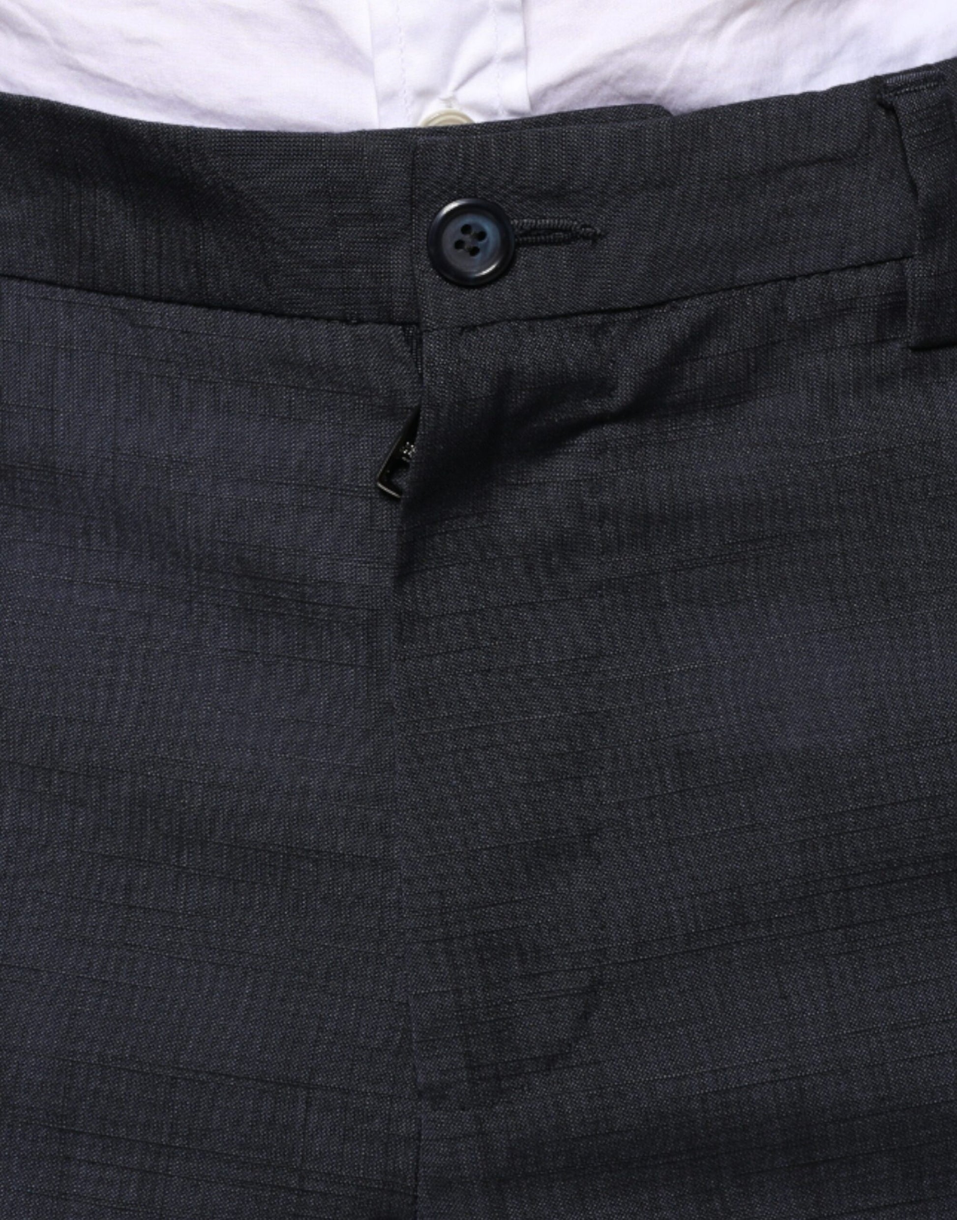 A pair of black wool formal dress pants from the brand Dolce & Gabbana. They feature a button and zipper clos