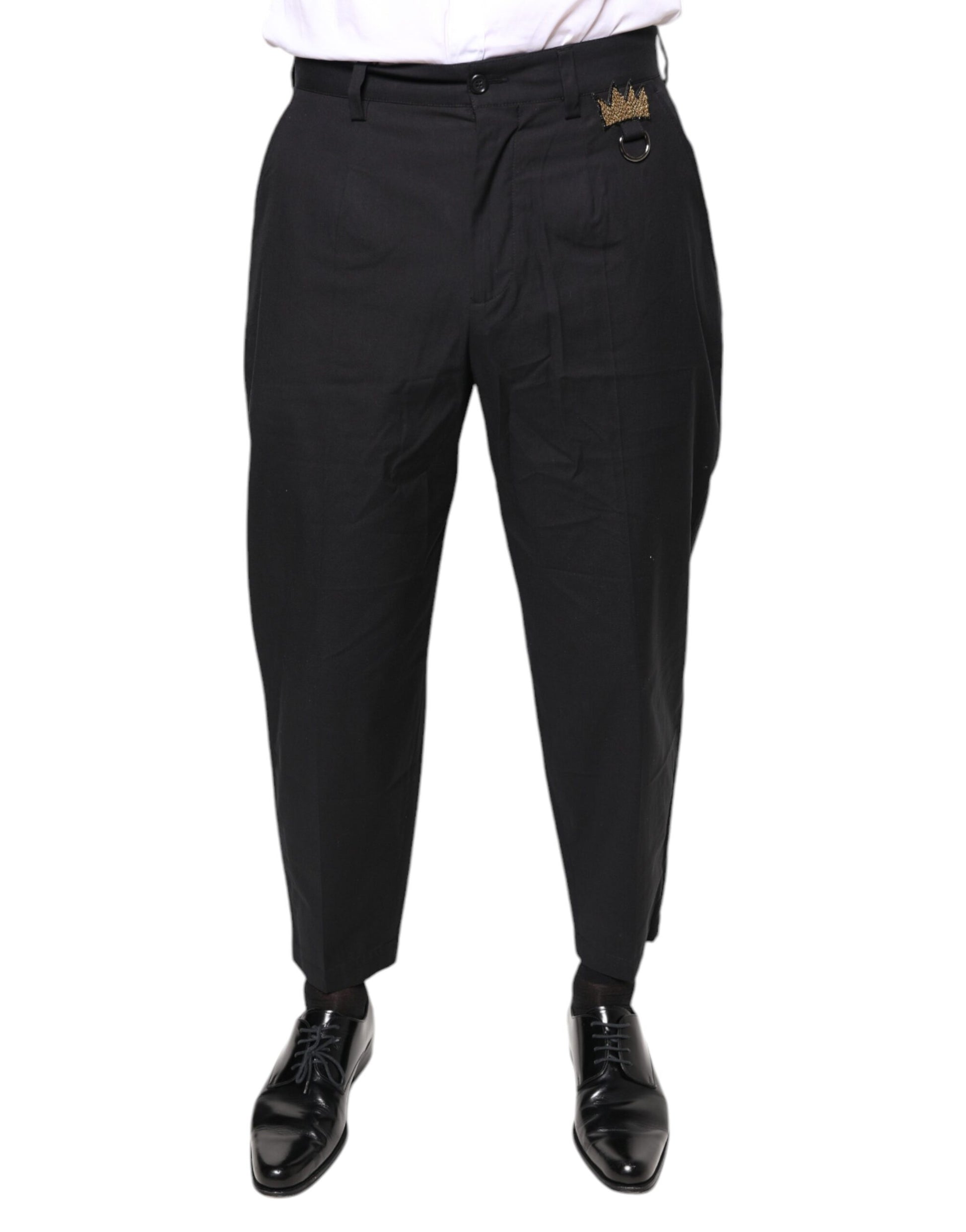 A pair of black dress pants with a crown logo on the waistband