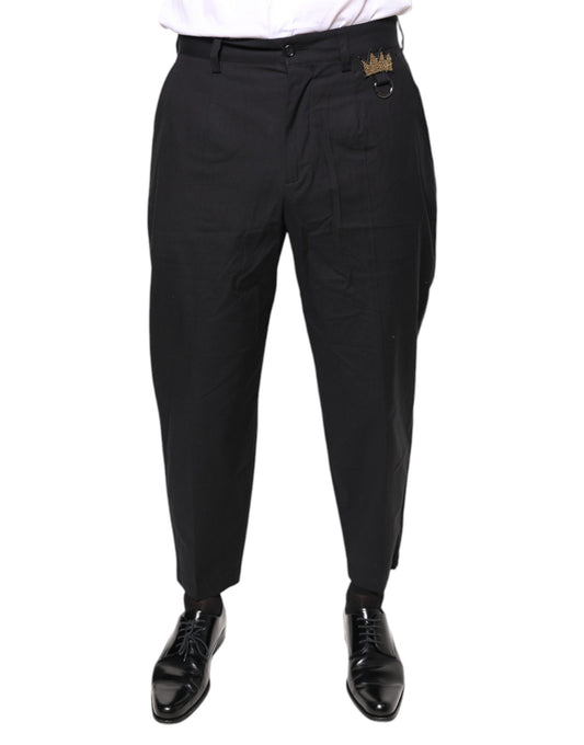A pair of black dress pants with a crown logo on the waistband