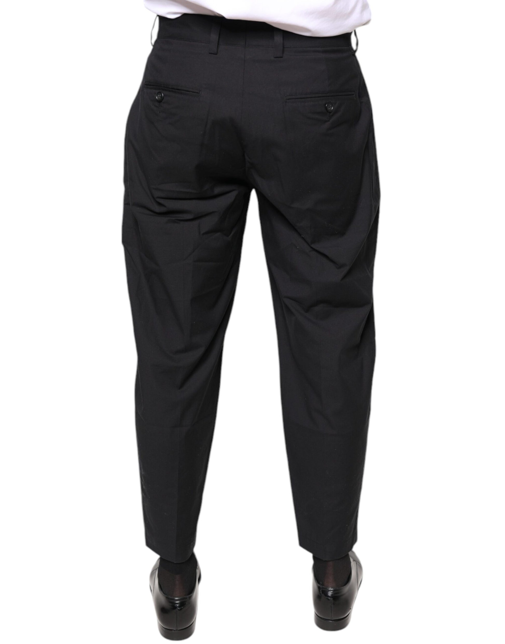 A pair of black dress pants with a crown logo on the waistband