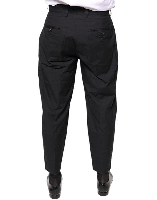 A pair of black dress pants with a crown logo on the waistband