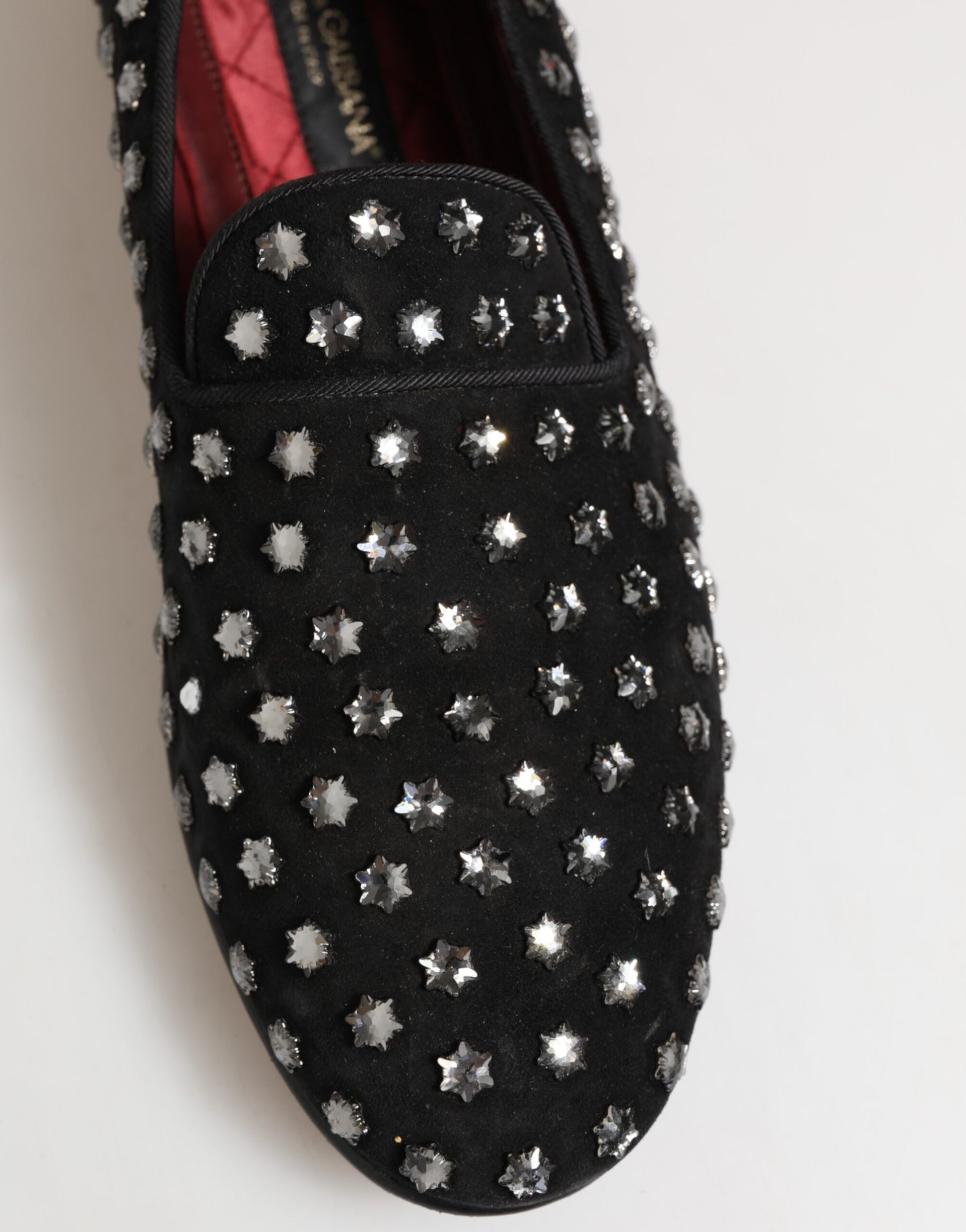 A pair of black loafers with crystal embellishments on the toe and heel