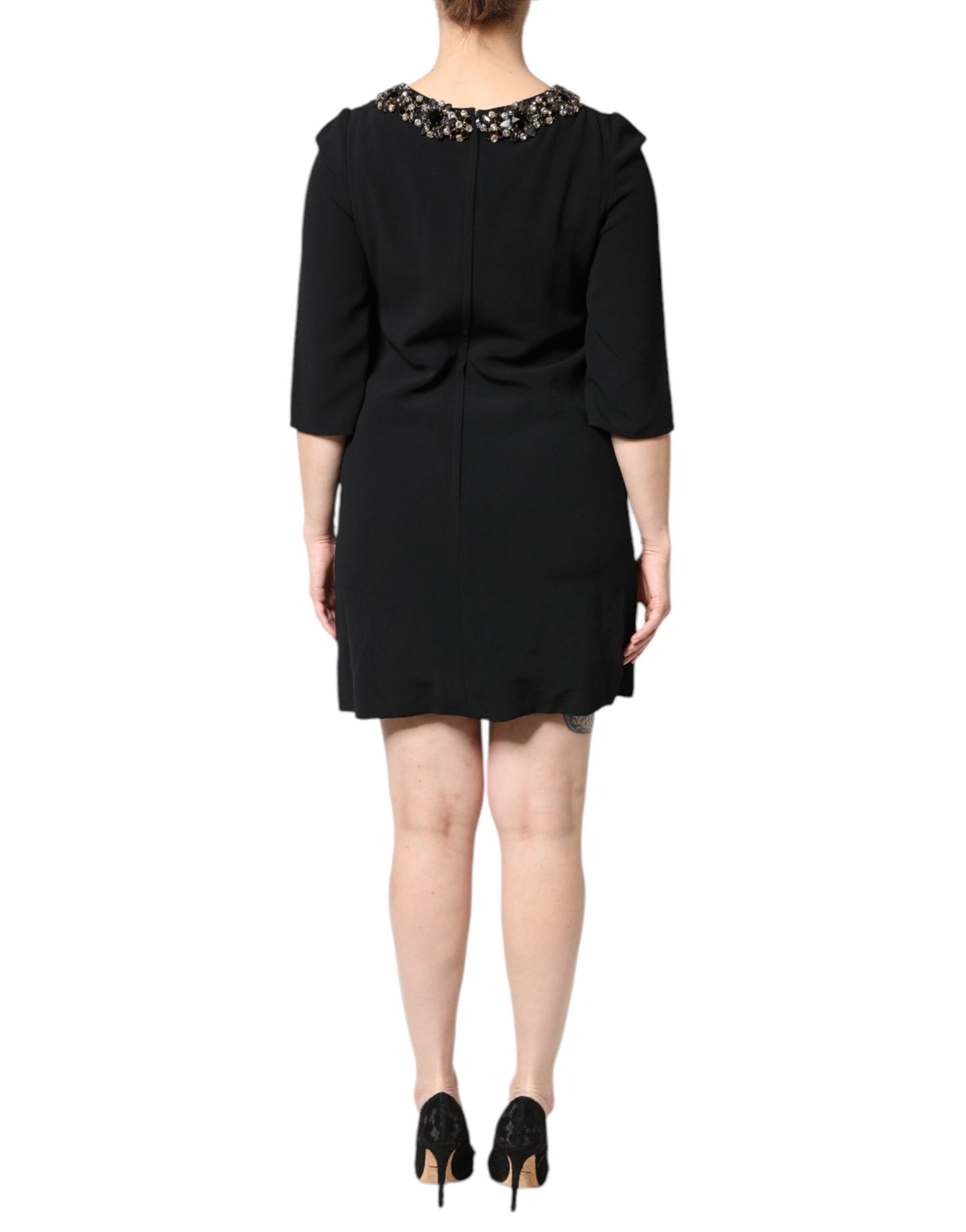A black dress with crystal embellishments on the neckline and sleeves