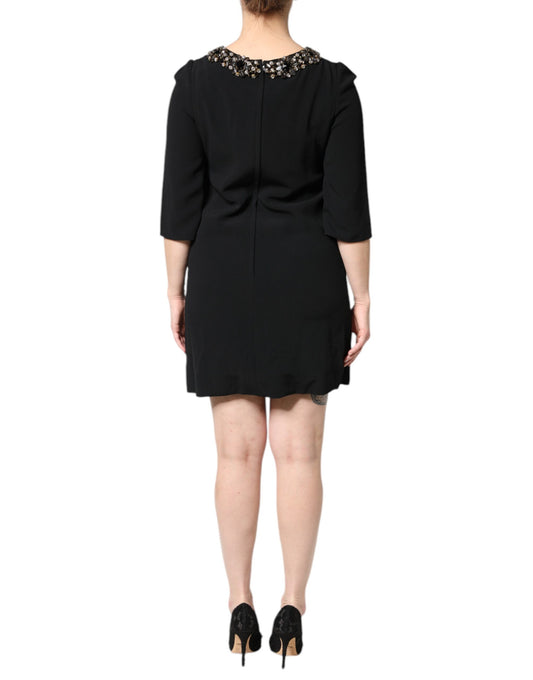 A black dress with crystal embellishments on the neckline and sleeves