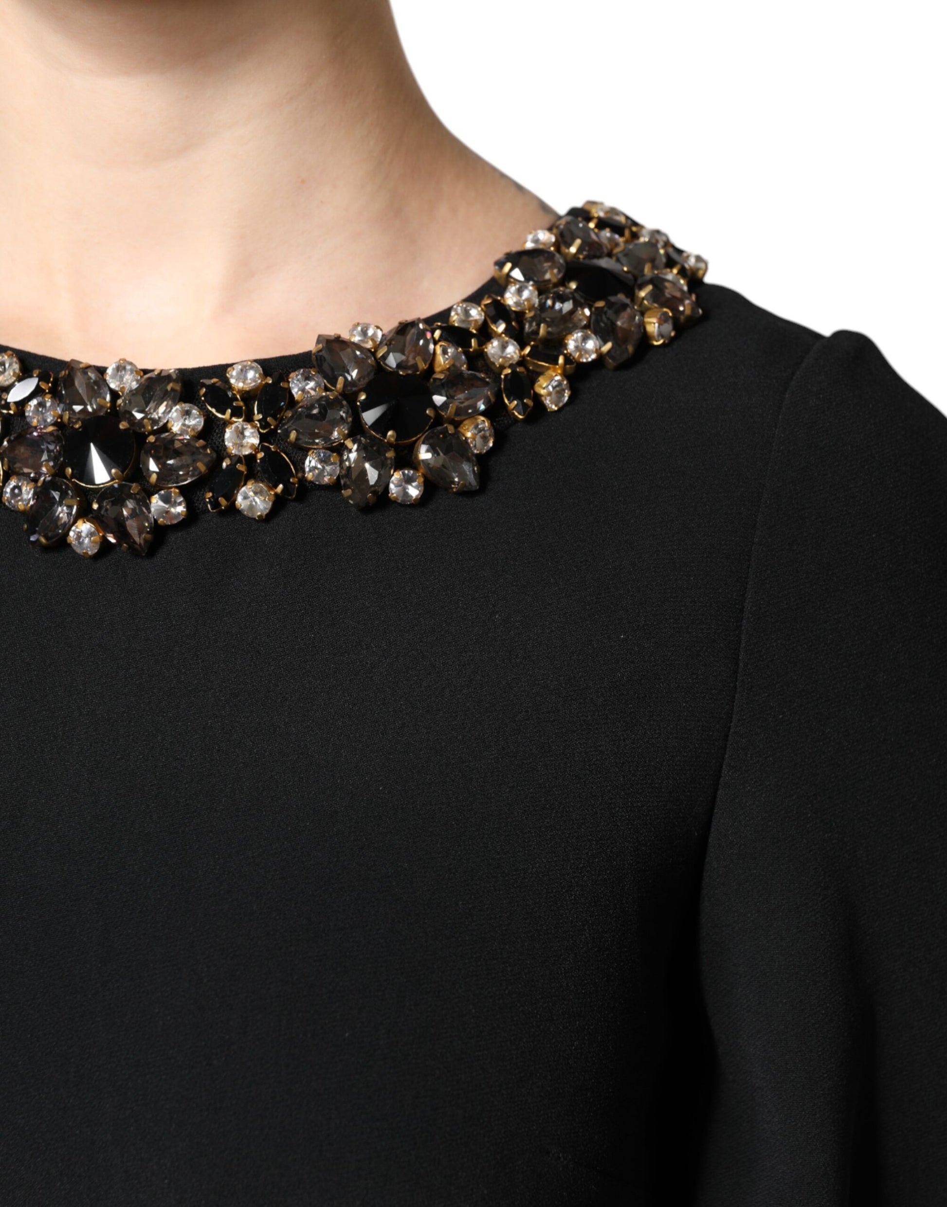 A black dress with a round neckline, embellished with crystals and beads