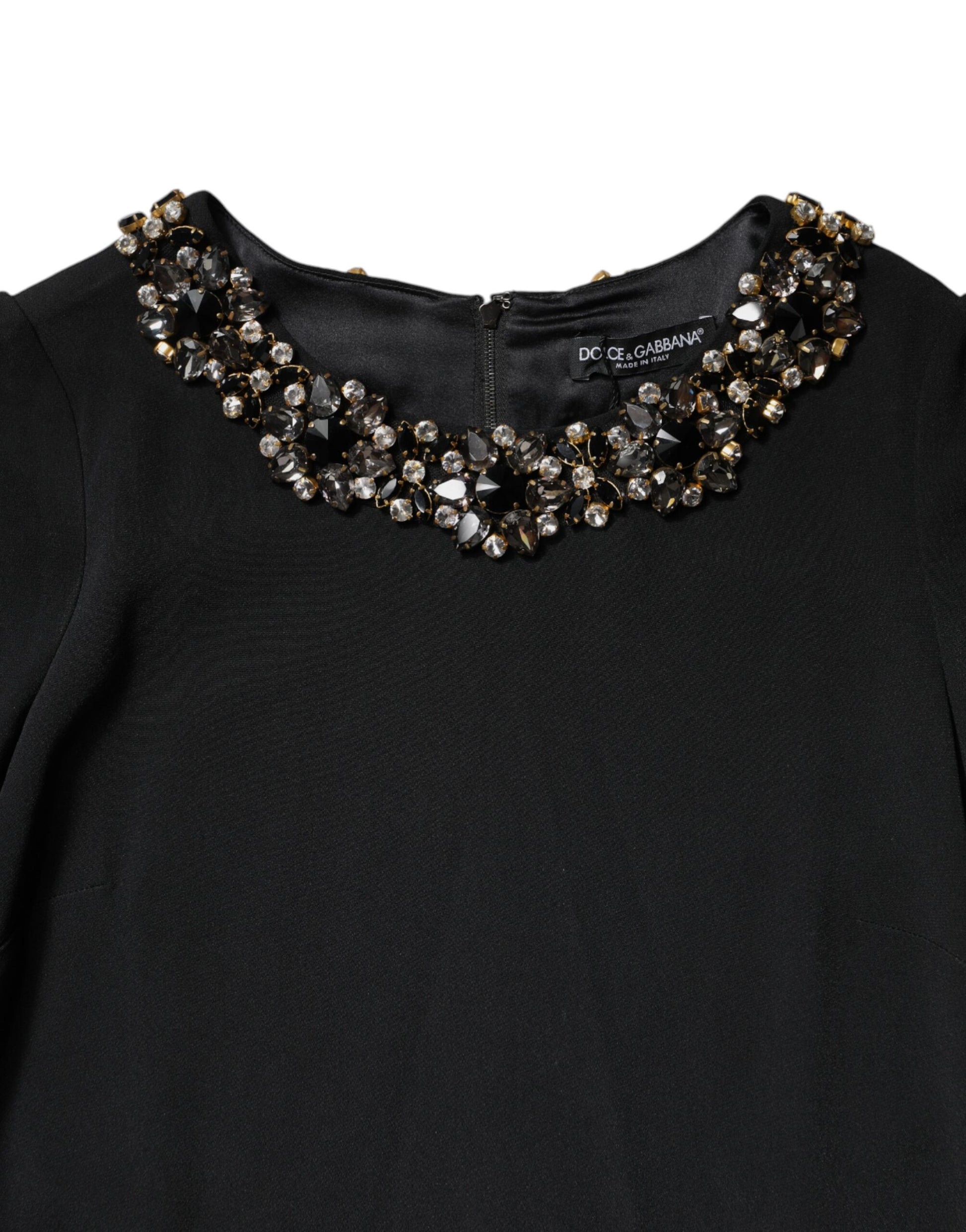 A black dress with a round neckline, featuring a crystal embellishment at the collar