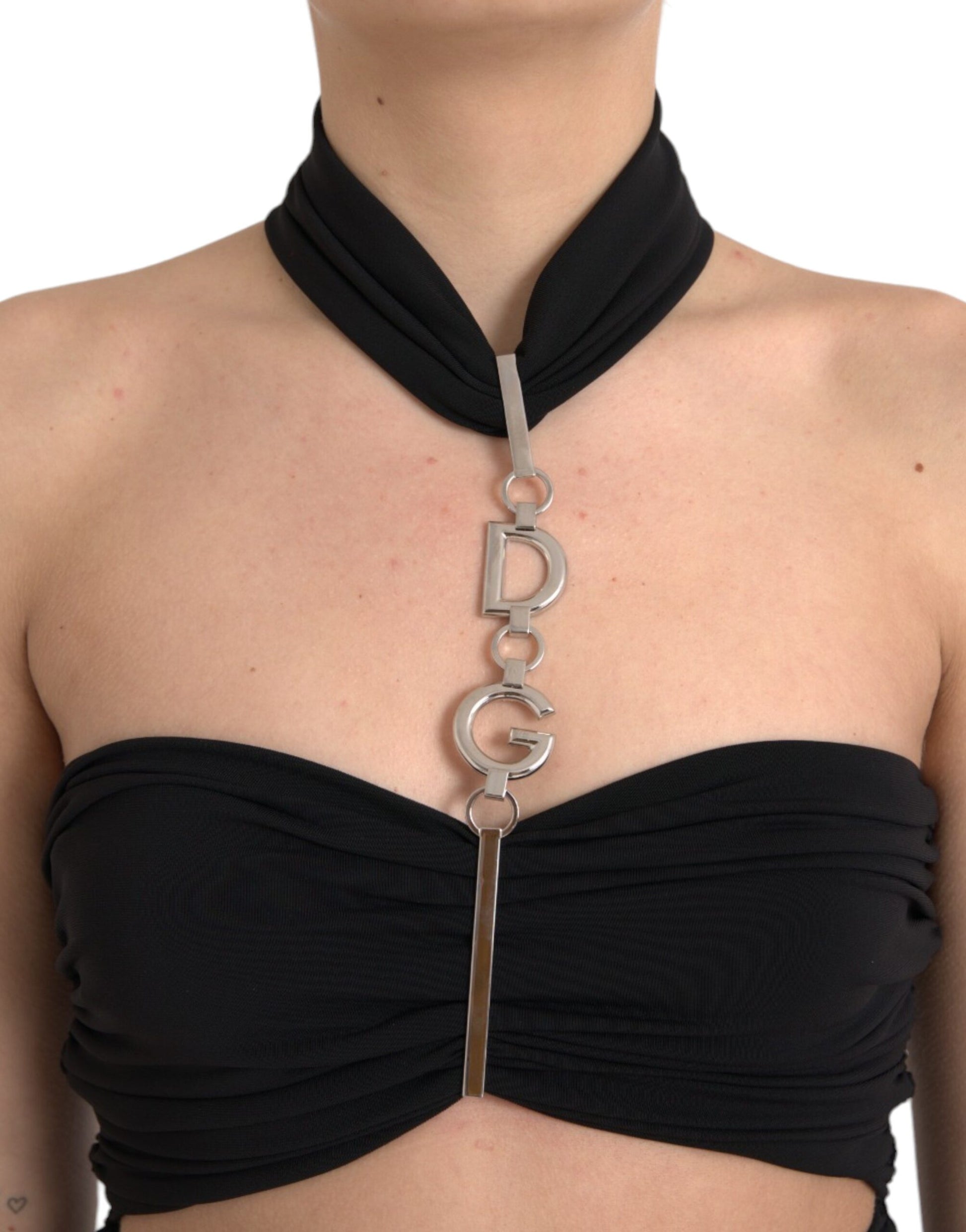 A black cut out sleeveless bodycon mini dress with a silver metal chain necklace