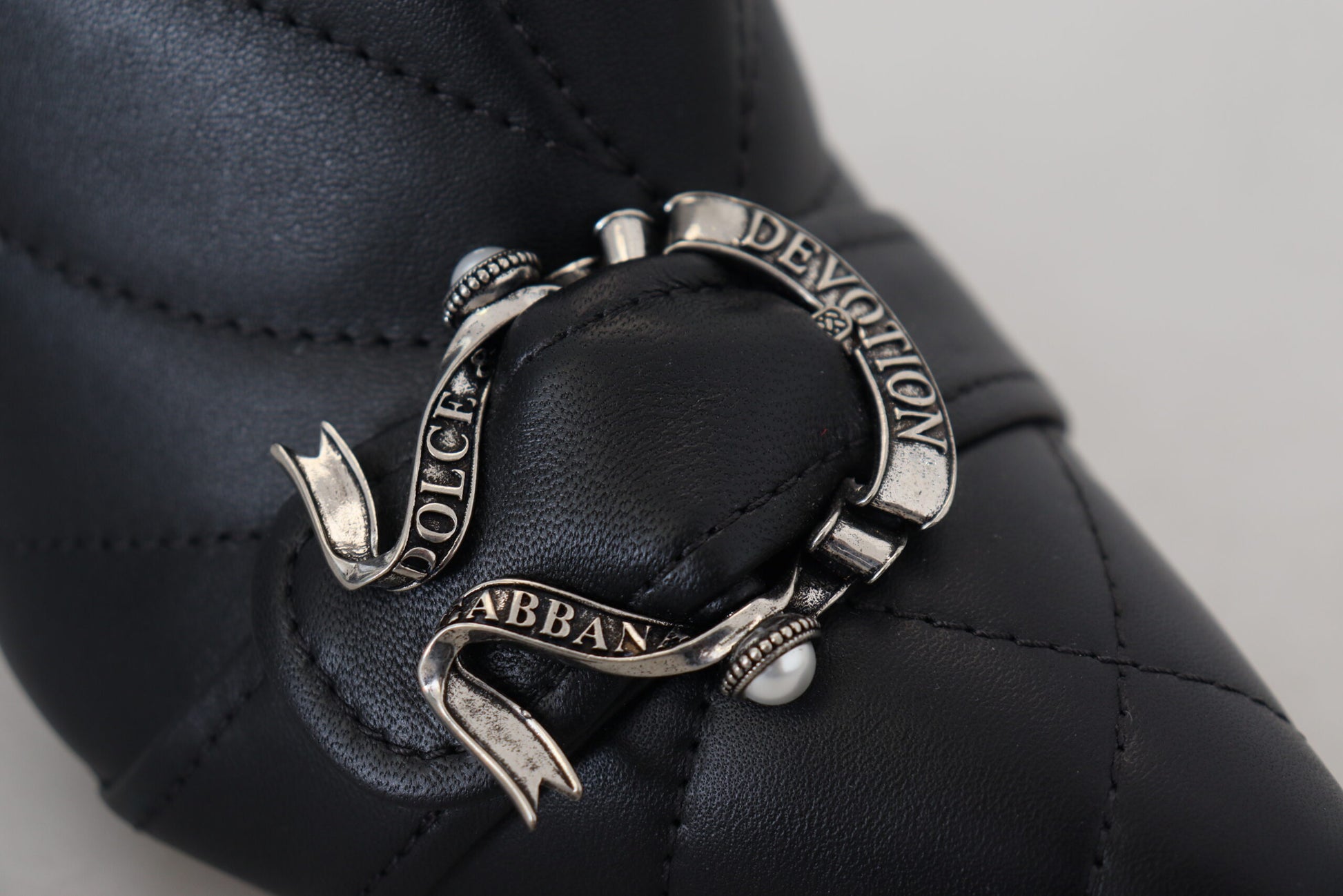 Silver bracelet with engraved words on a black leather surface