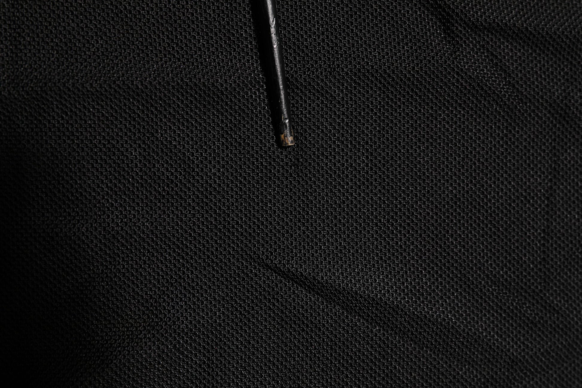 Black fabric with a small hole in it