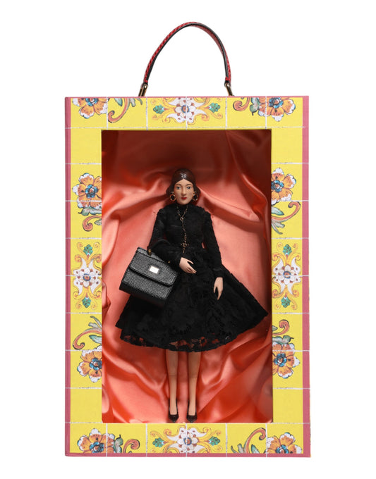 A porcelain doll wearing a black dress with lace and leather details, holding a purse