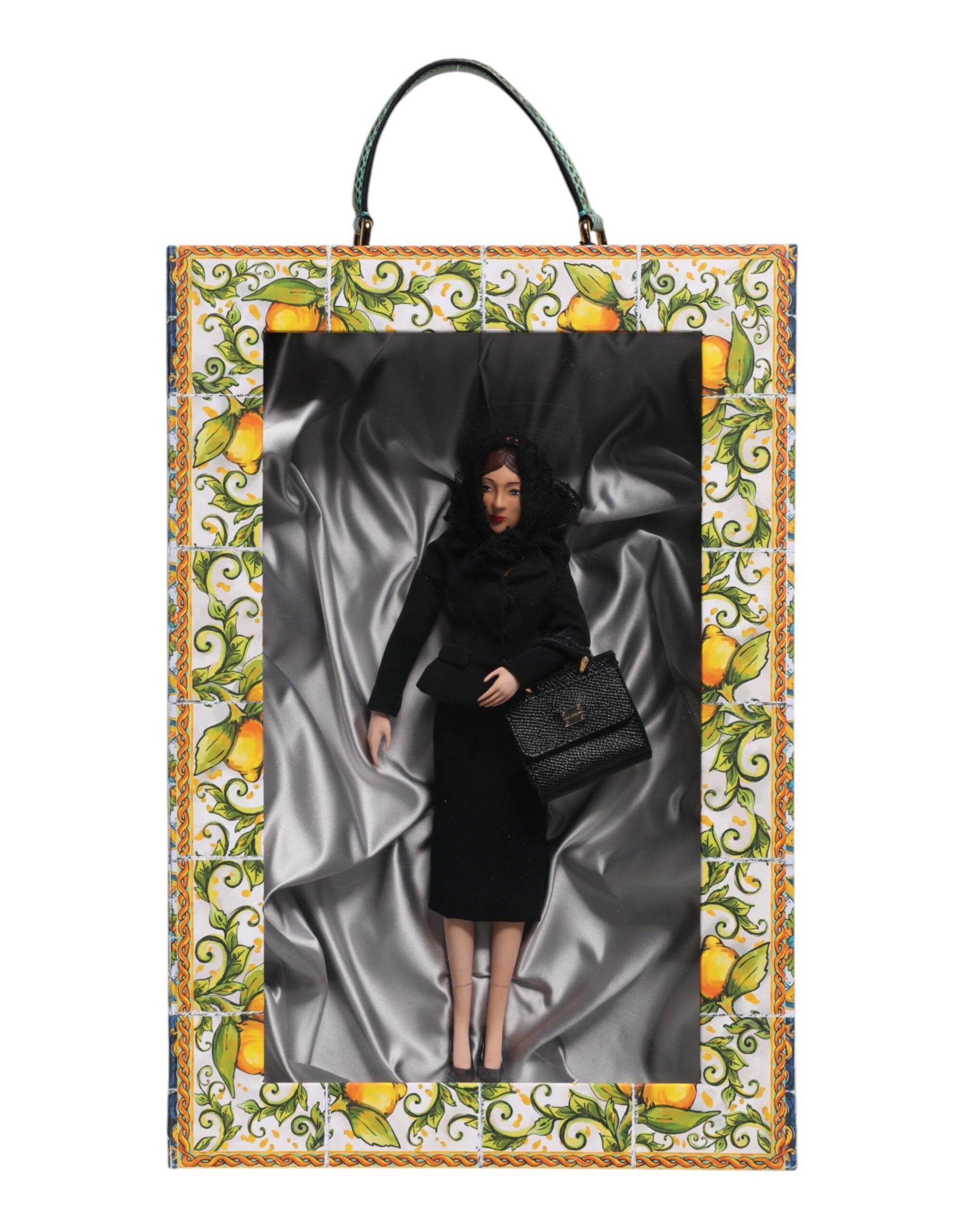 A porcelain doll wearing a black dress with leather details, designed by Dolce & Gabbana