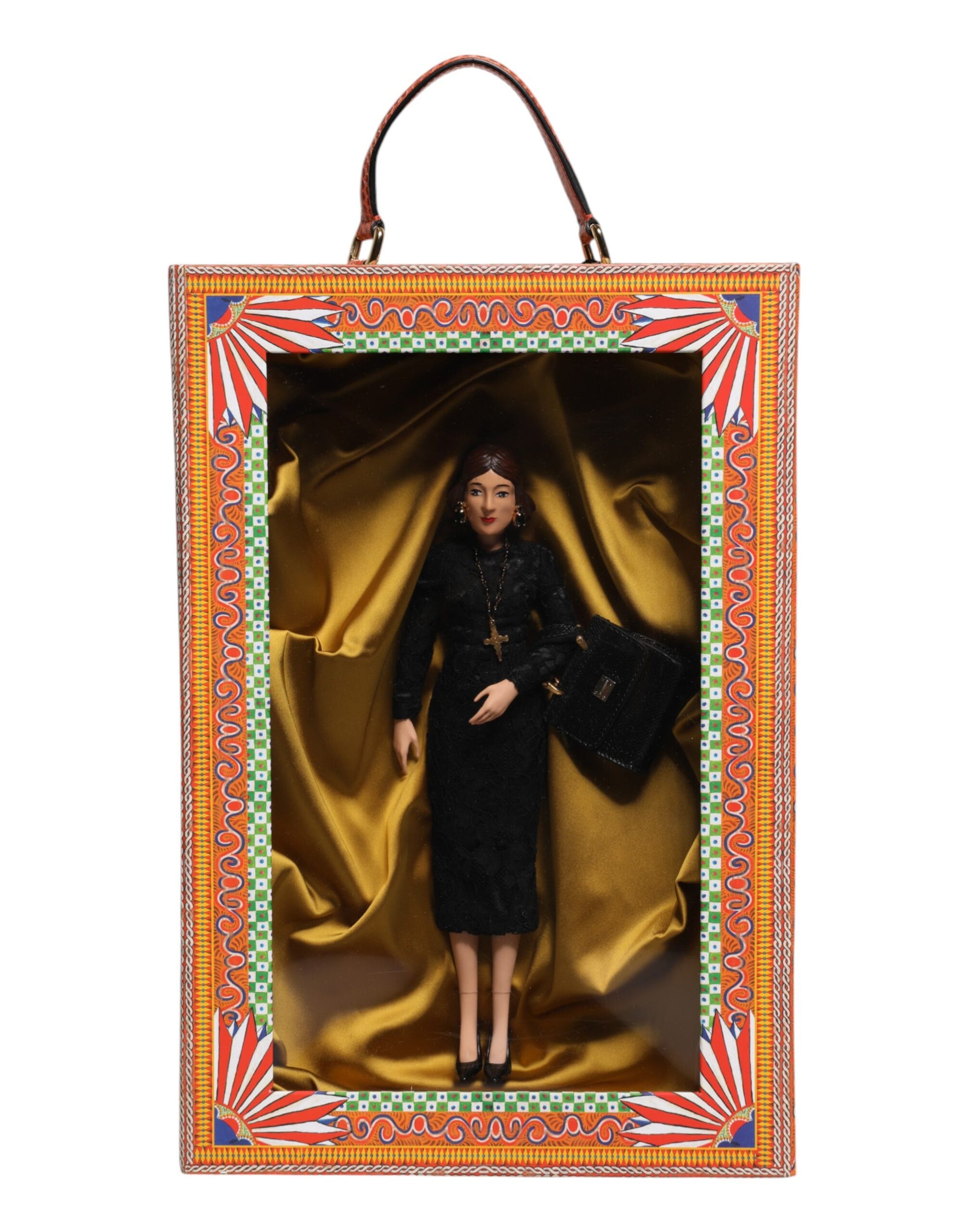A porcelain doll wearing a black dress with gold accents